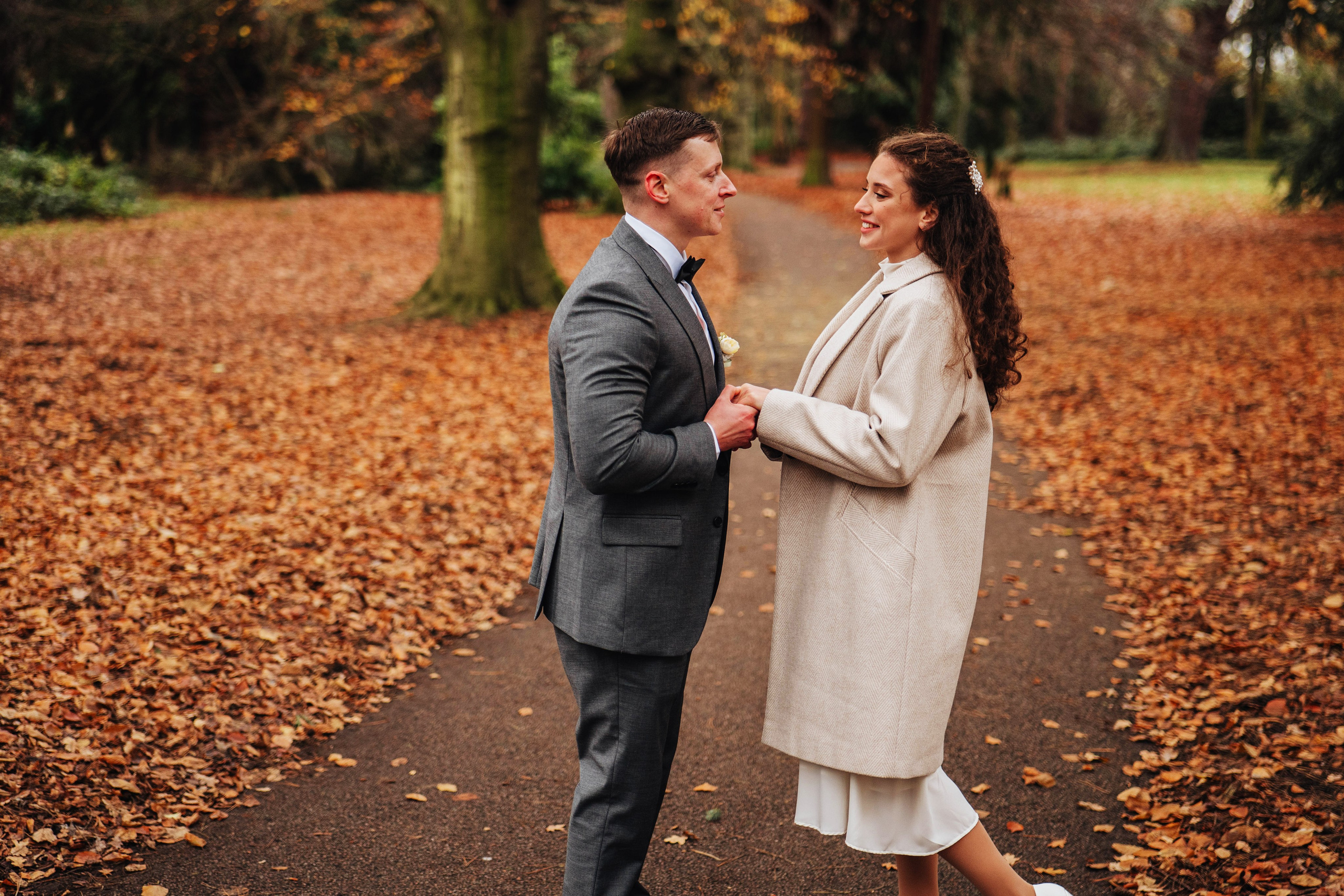 bride and groom looking at each other while holding hands