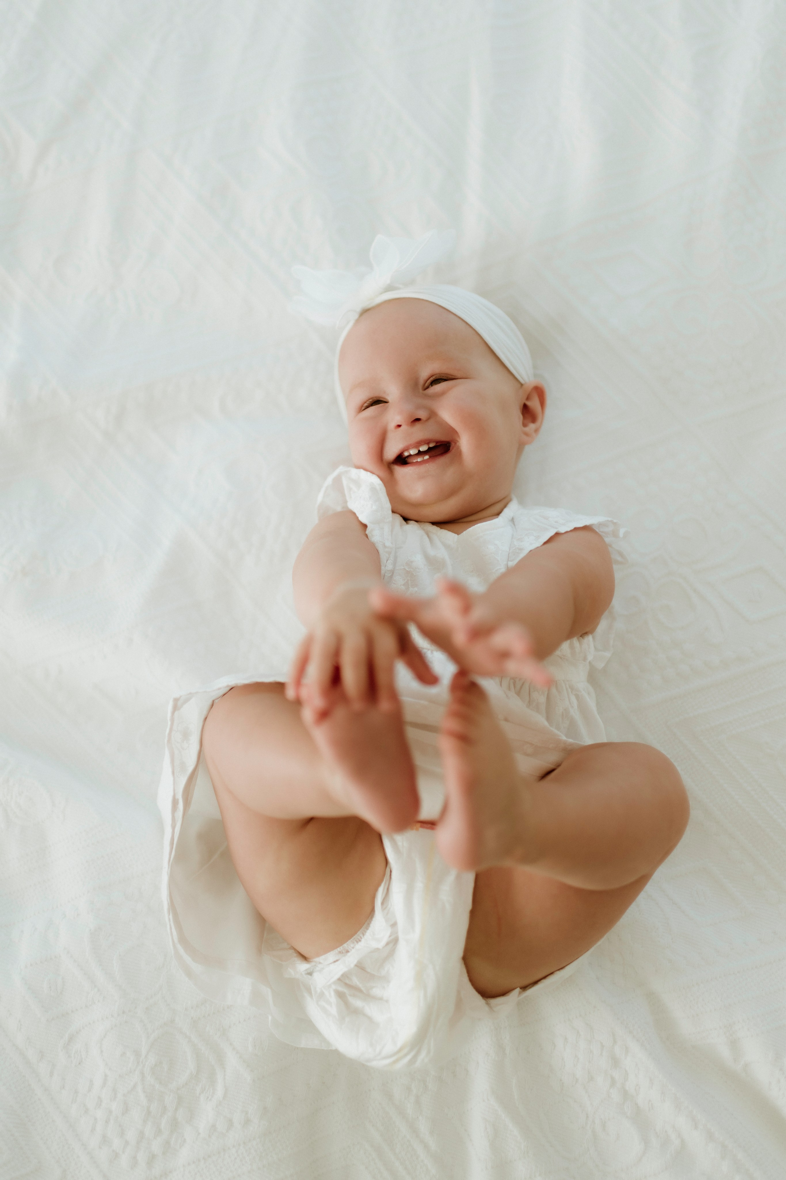 An enchanting outdoor maternity photoshoot at the client's house. The image features a radiant mother and her daughter, both elegantly dressed in white, against the backdrop of their home. The simplicity of their attire and the natural surroundings creates a timeless and intimate atmosphere. Book a personalized outdoor session with MD Studio to capture beautiful moments in the comfort of your own home