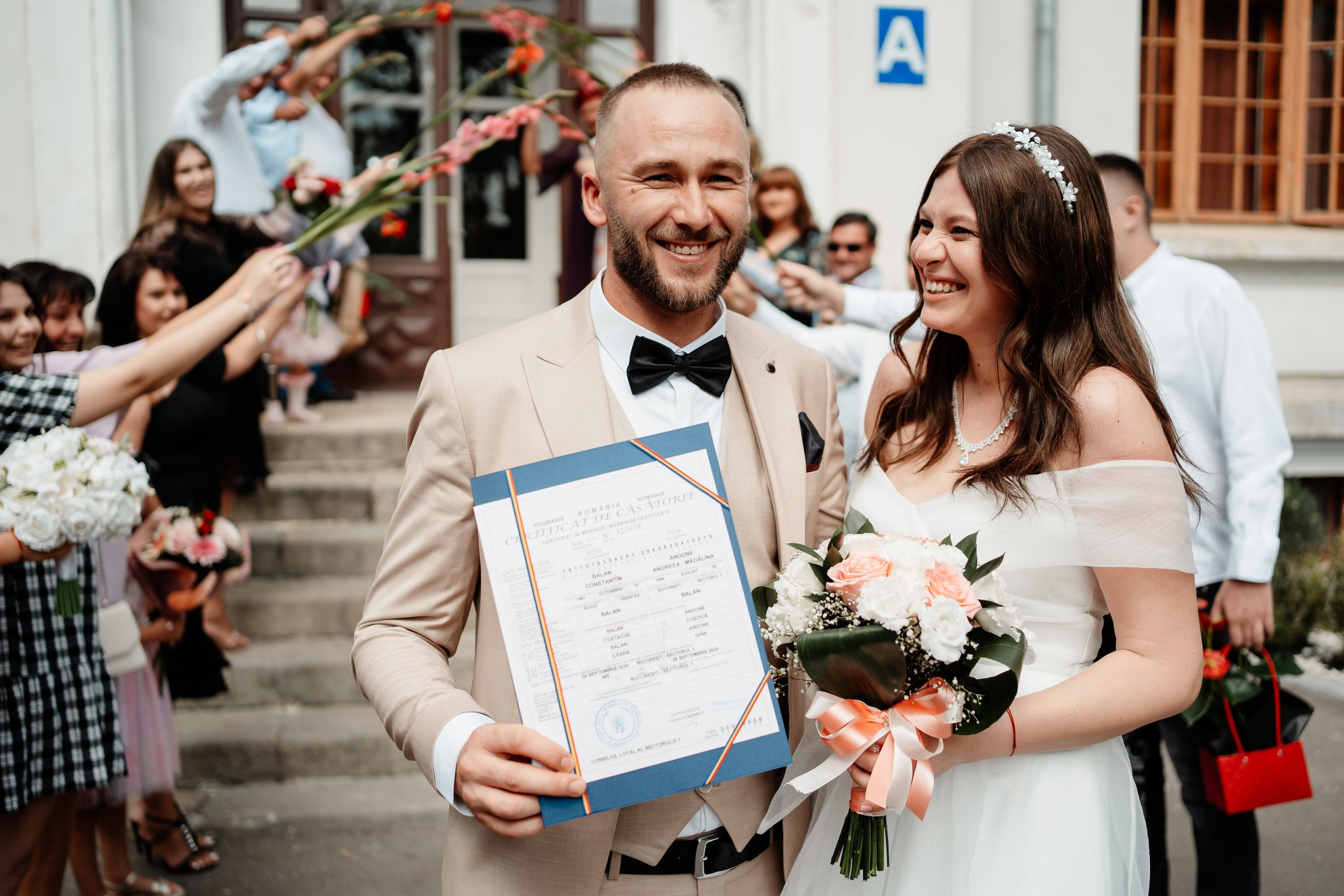 Miri fericiți în fața oficiului stării civile din Bucuresti, Sector 1, celebrând începutul unei noi vieți împreună. Fotografie de cununie civilă, capturând naturalețea și bucuria momentului special.
