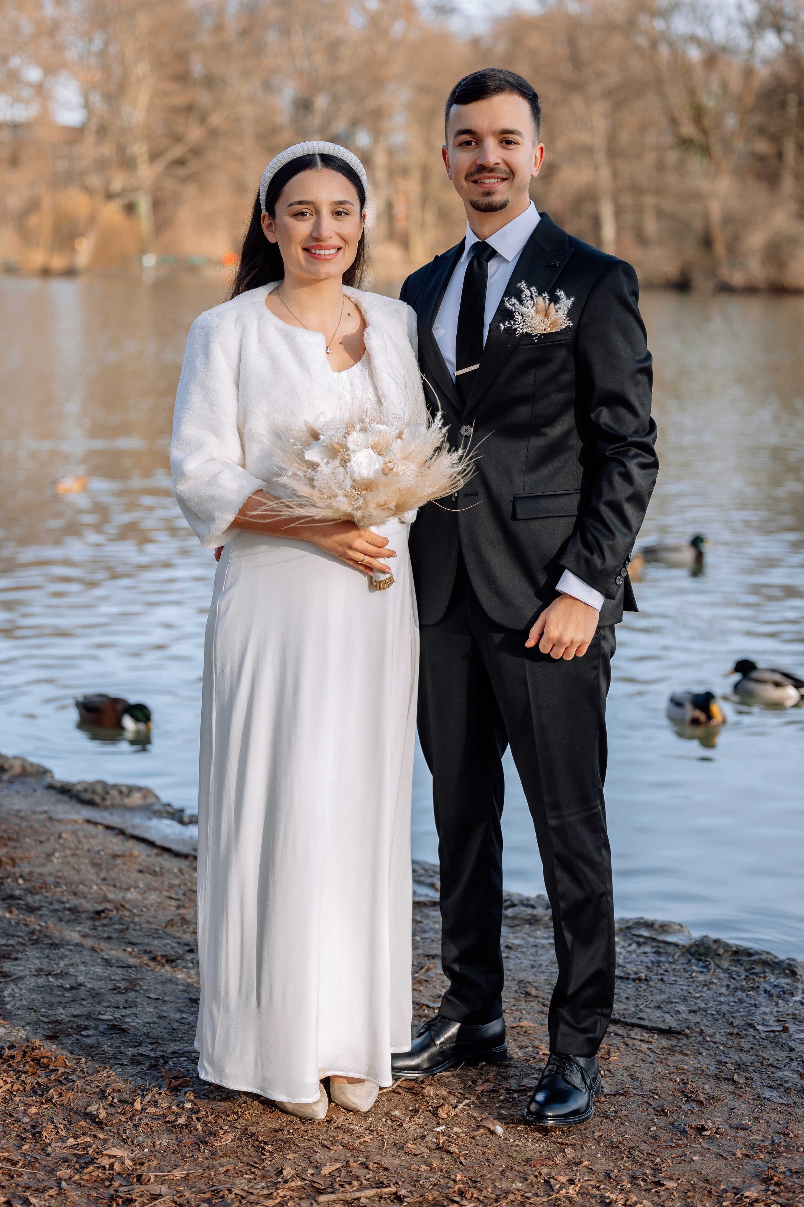 Braut im weißen Kleid zeigt Babybauch – elegante Schwangerschaftsfotografie Mandlstraße 14