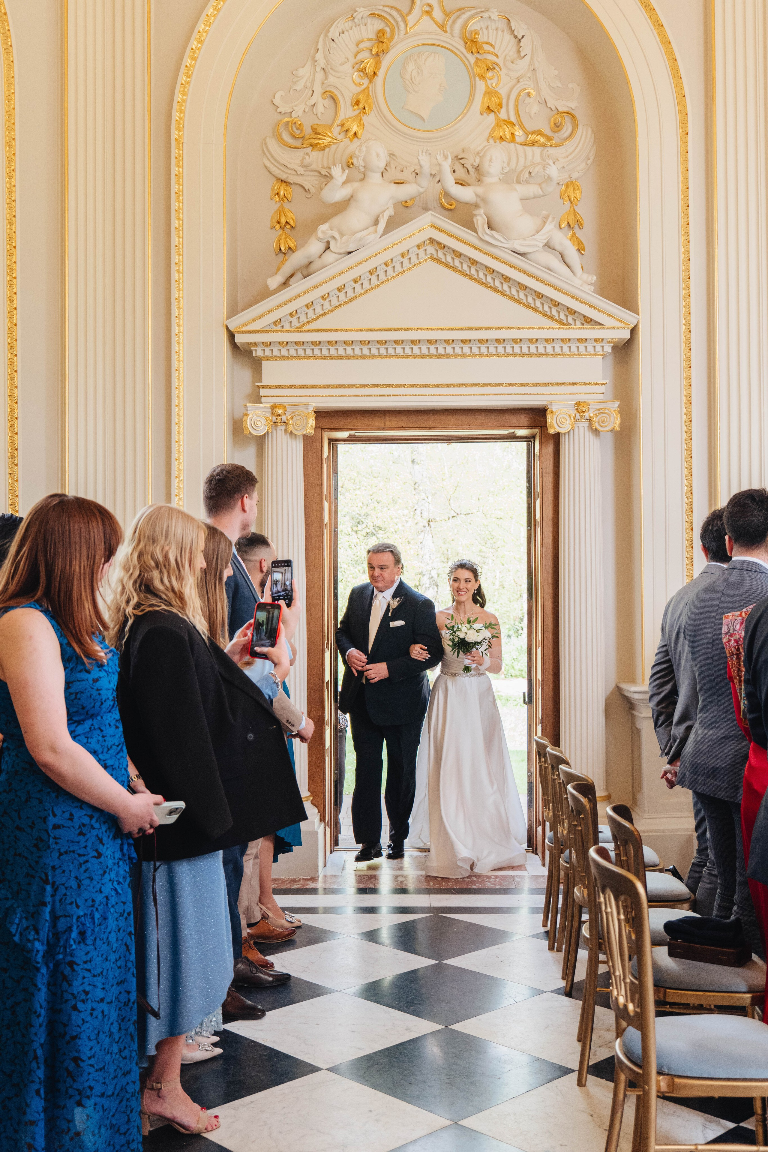 bride arriving through doors at the venue with her father