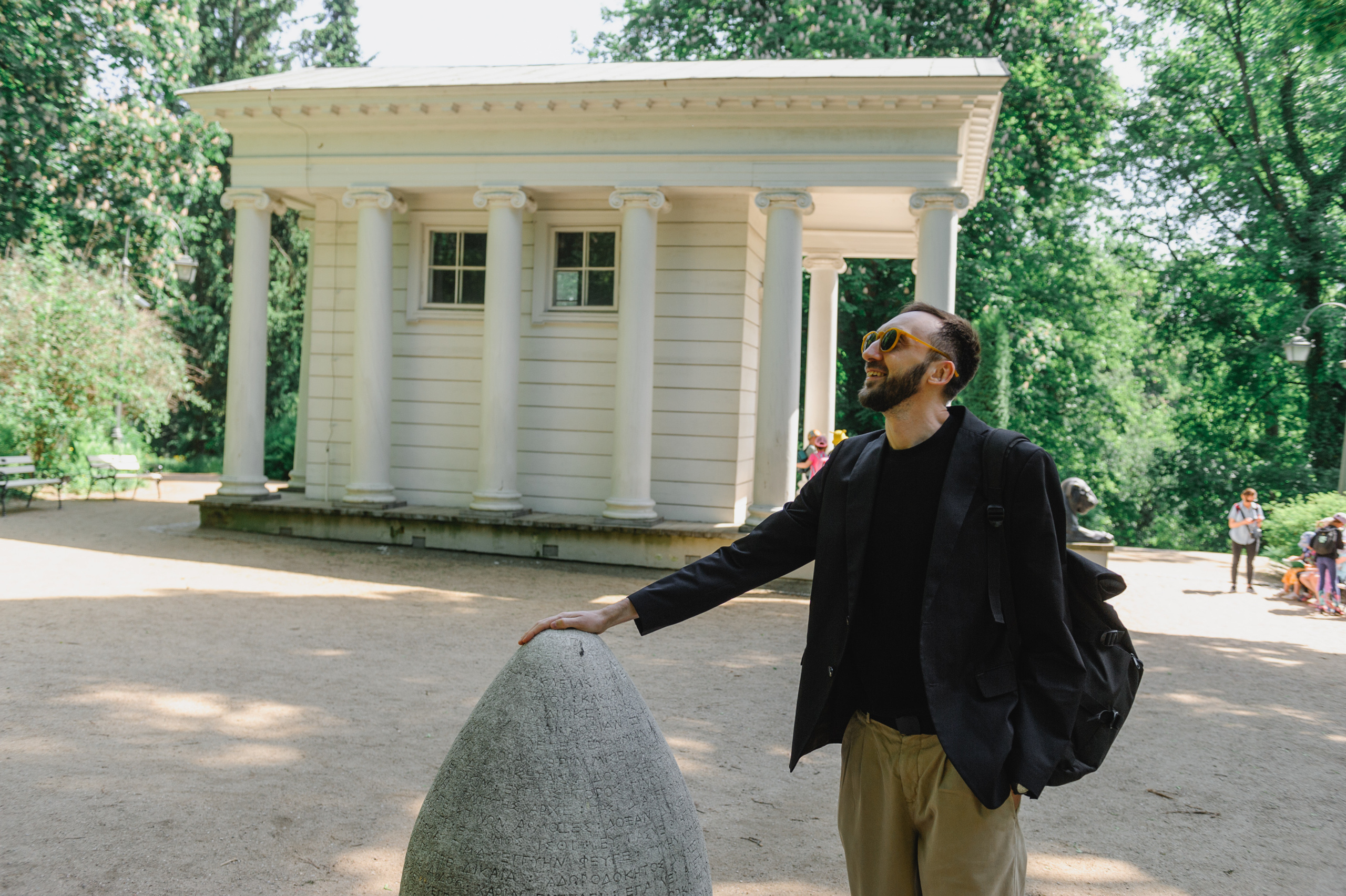 Молодой человек держится за яйцеобразную каменную скрижаль