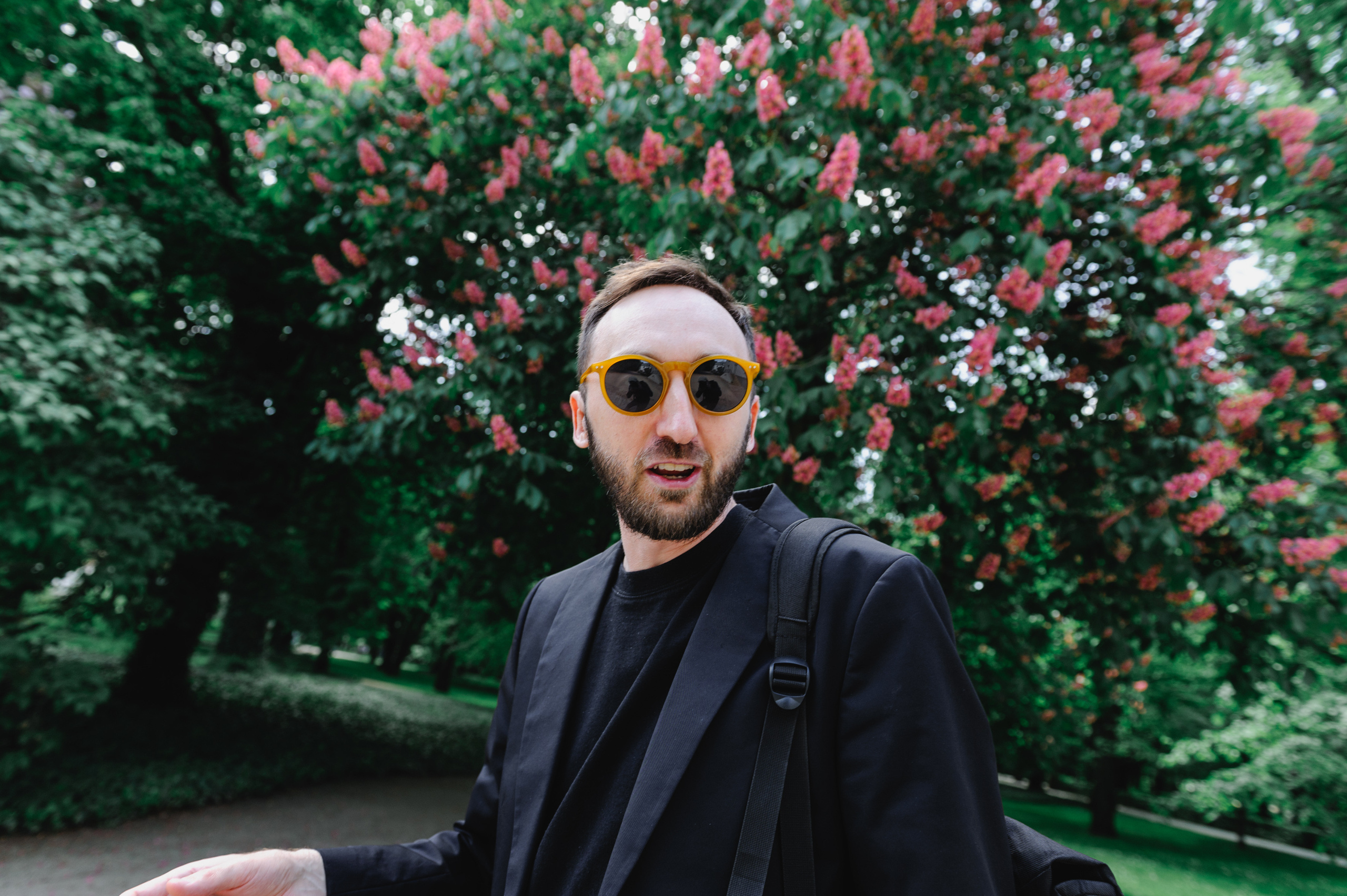 Культуролог Дмитрий Солодкий и цветущий красный каштан на фоне