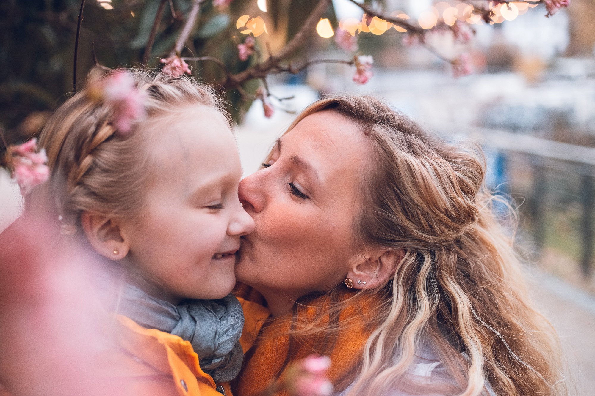 Mama küsst ihre Tochter Teenager am Wasser