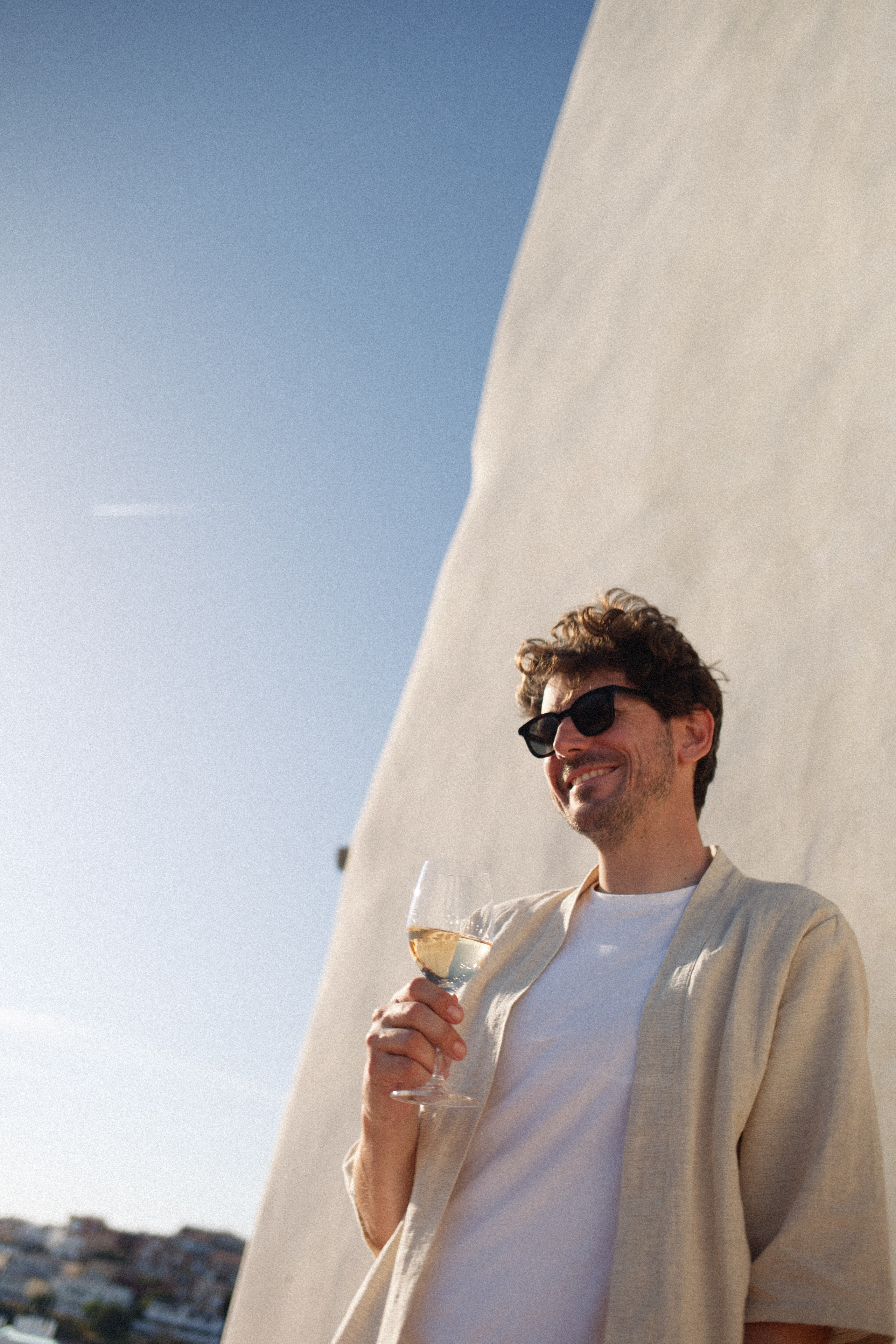 A man smiling while holding a glass of Mart rosé ecological wine 