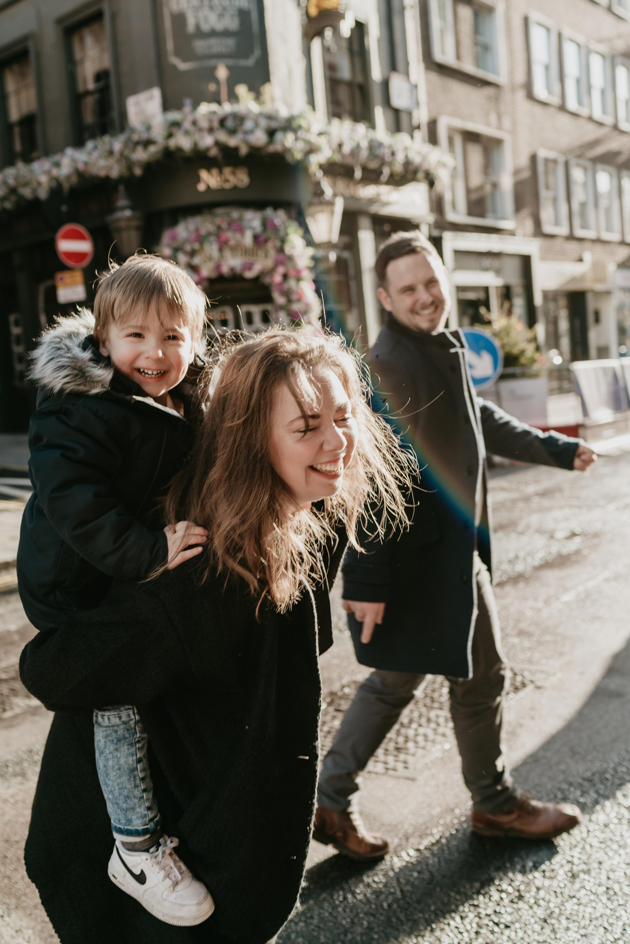 kid sitting on his mother bag