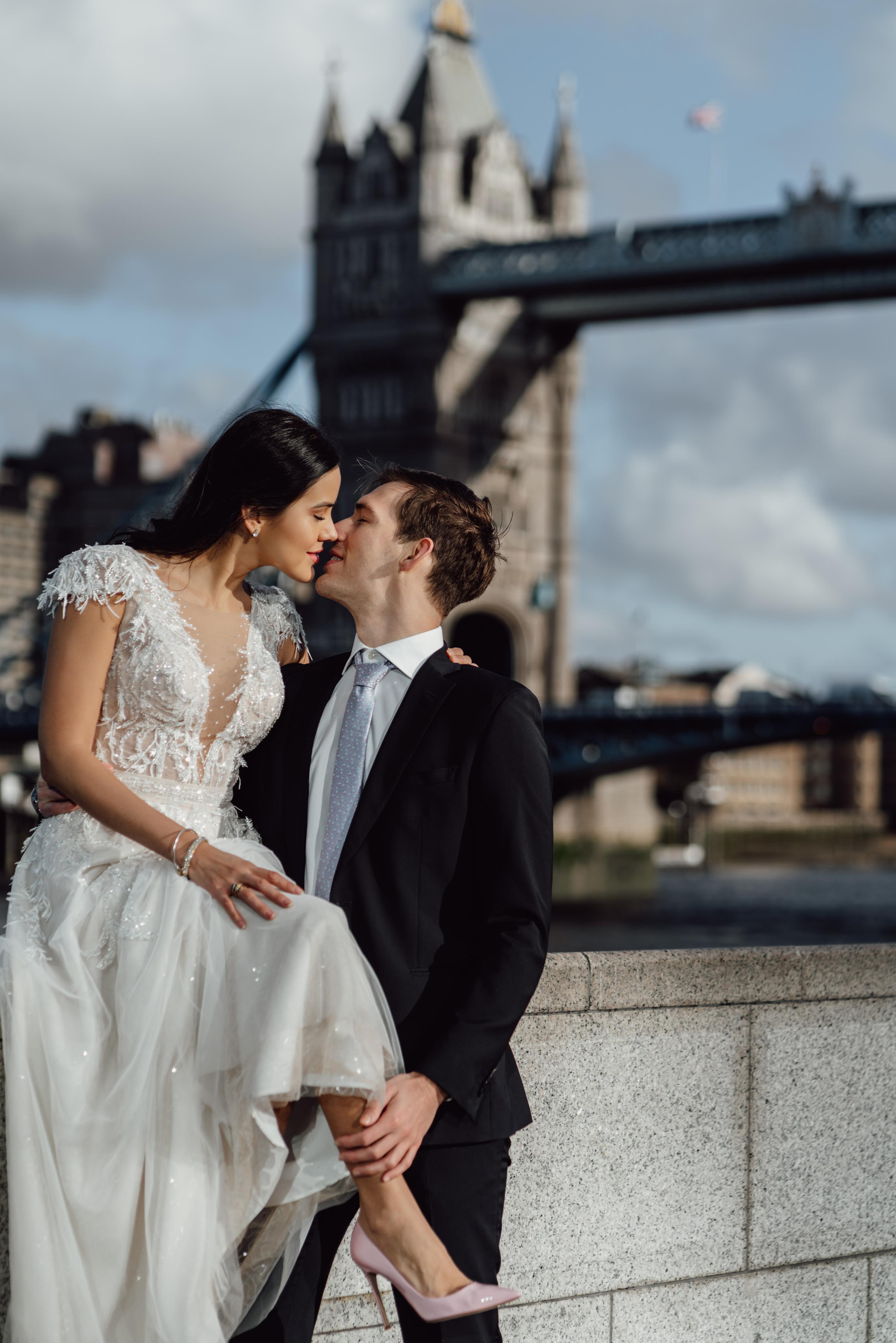 bride and groom kissing with London city on the background 