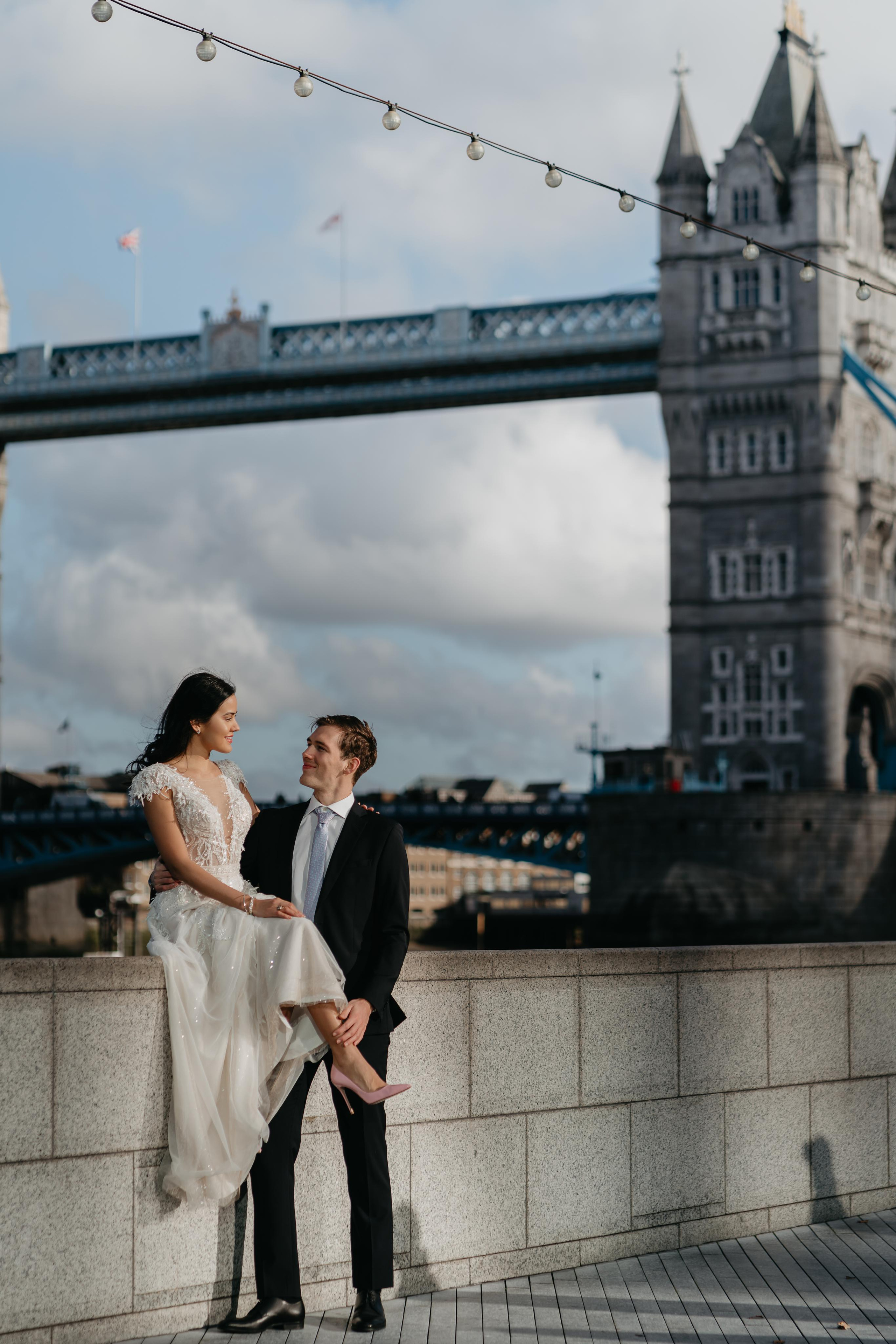 just married couple posing with tower bridge on the background 