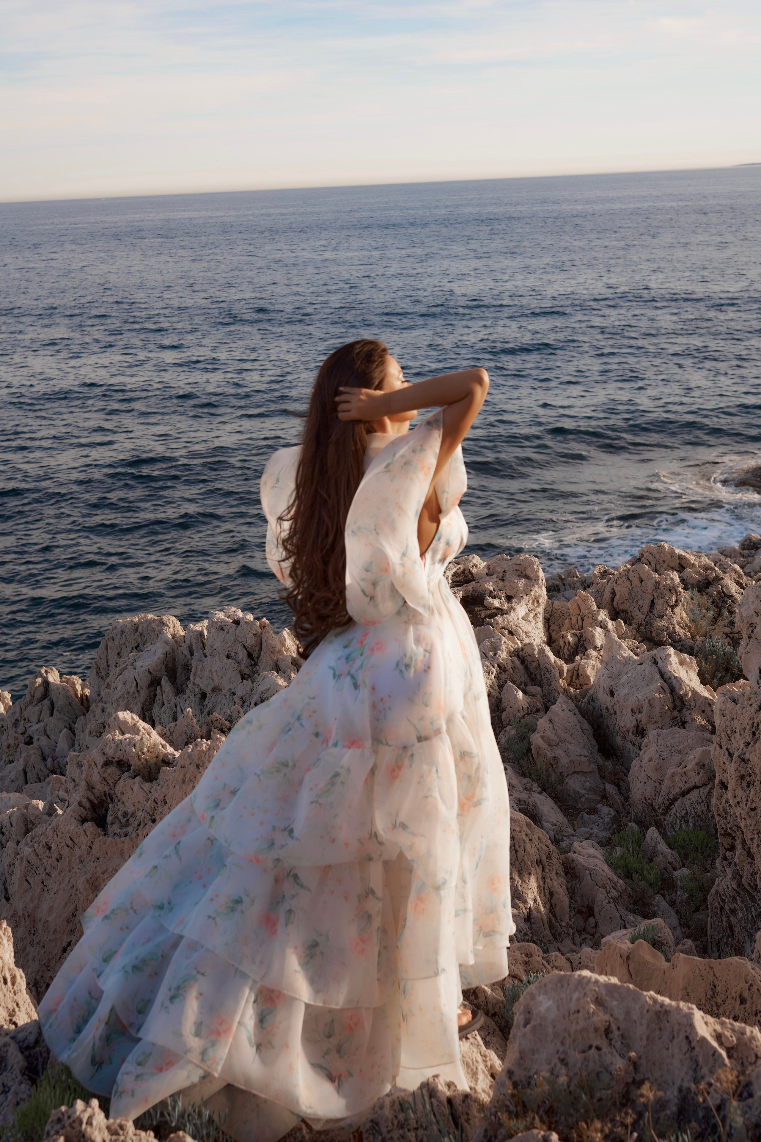 Glamorous outdoor portrait of model in organza gown against turquoise sea Saint-Jean-Cap-Ferrat