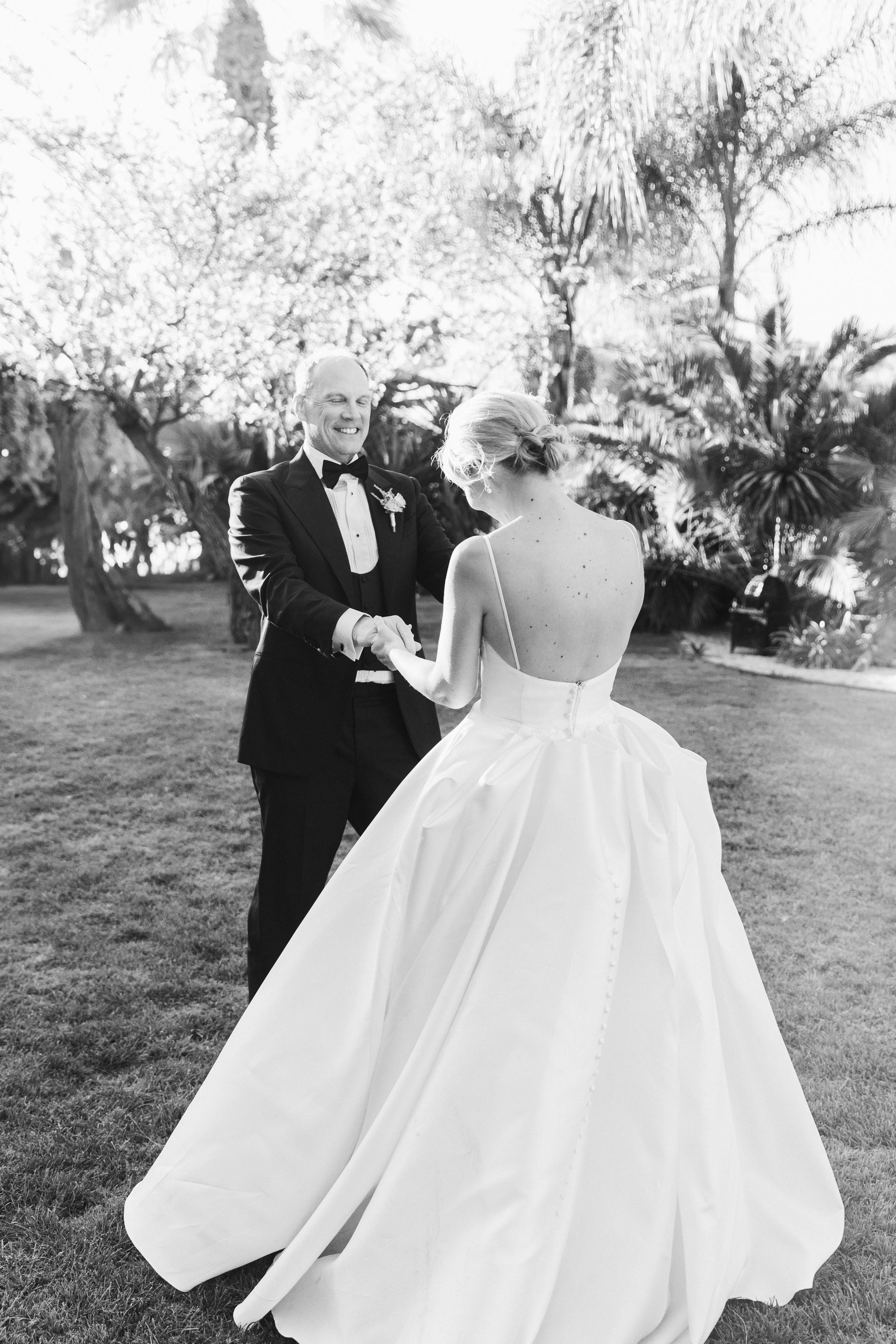 The bride and the groom are dancing in the garden of the wedding venue in Barcelona 