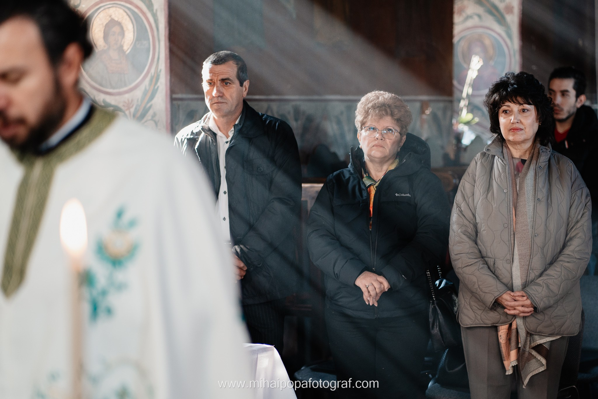Instantaneu plin de tandrețe dintre părinți și bebeluș în ziua botezului, realizat în ilfov. Fotografie profesională de botez, capturând emoțiile autentice ale familiei într-un decor luminos și cald