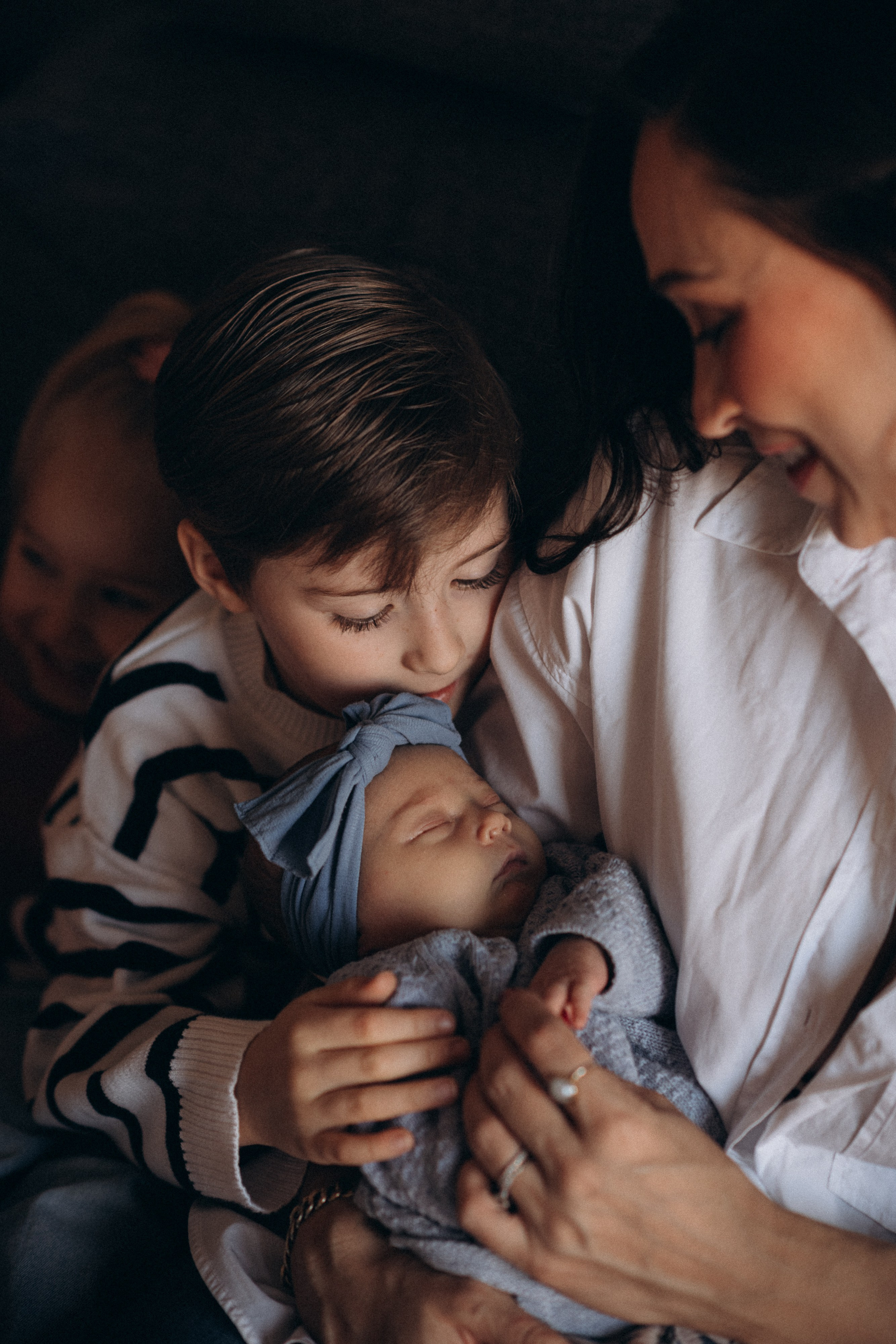 boy kissing his newborn baby sister