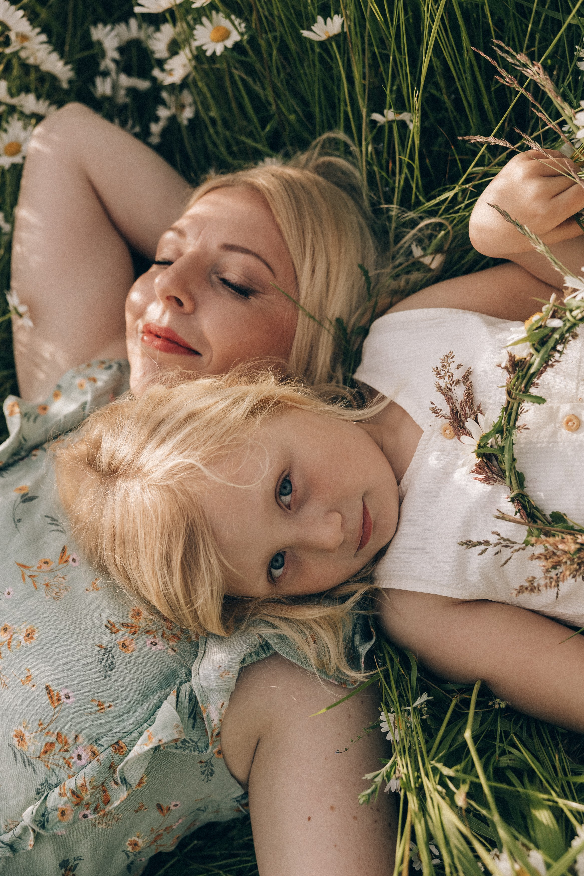 Family photoshoot in a daisy meadow at golden hour — natural light, warm tones, candid moments between a mother and her daughters. Lifestyle and Family Photographer in Pisek Oxana Telupilova