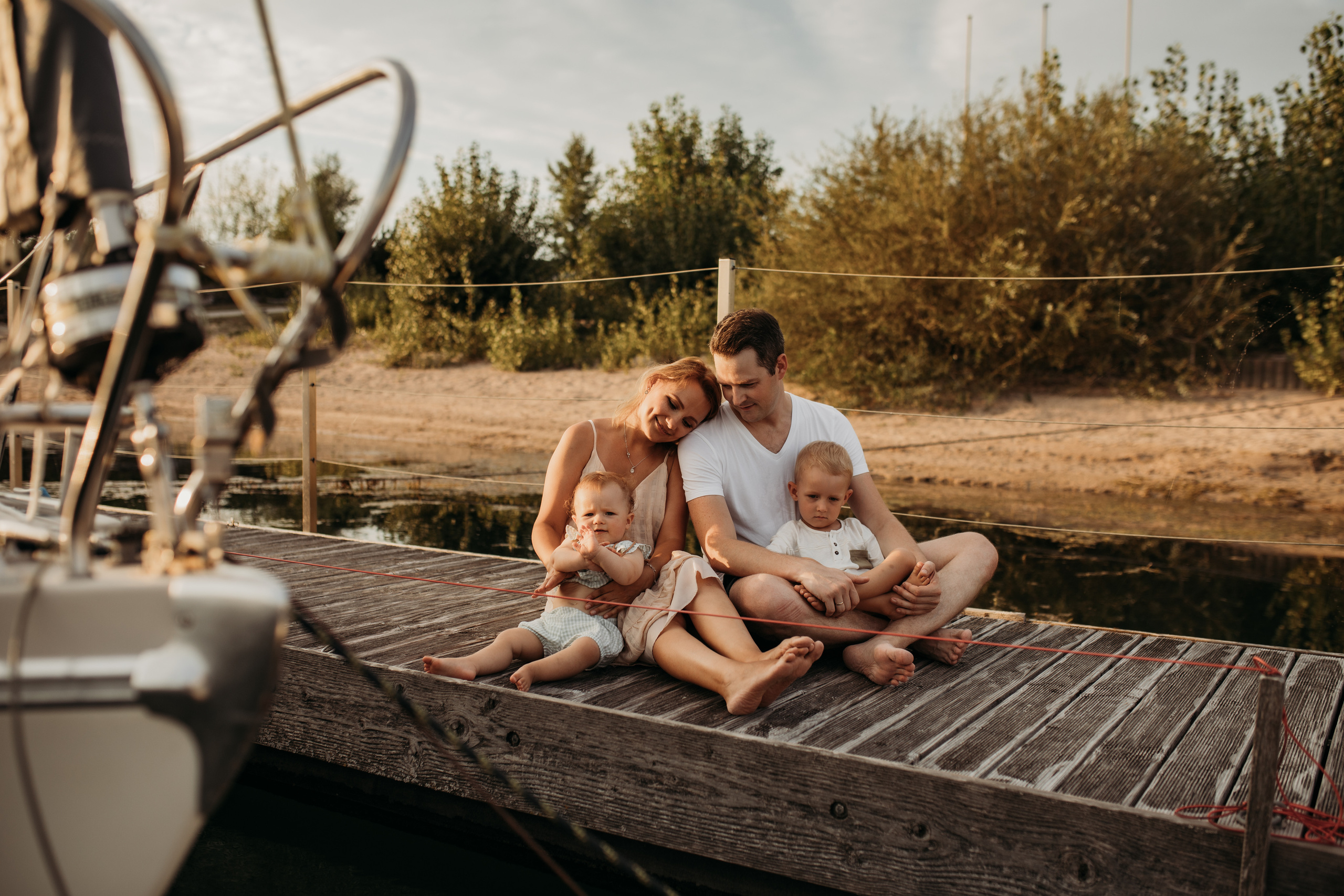 Mutter und Vater kuscheln mit ihren Kindern auf dem Strand beim Familienshooting in Mannheim.