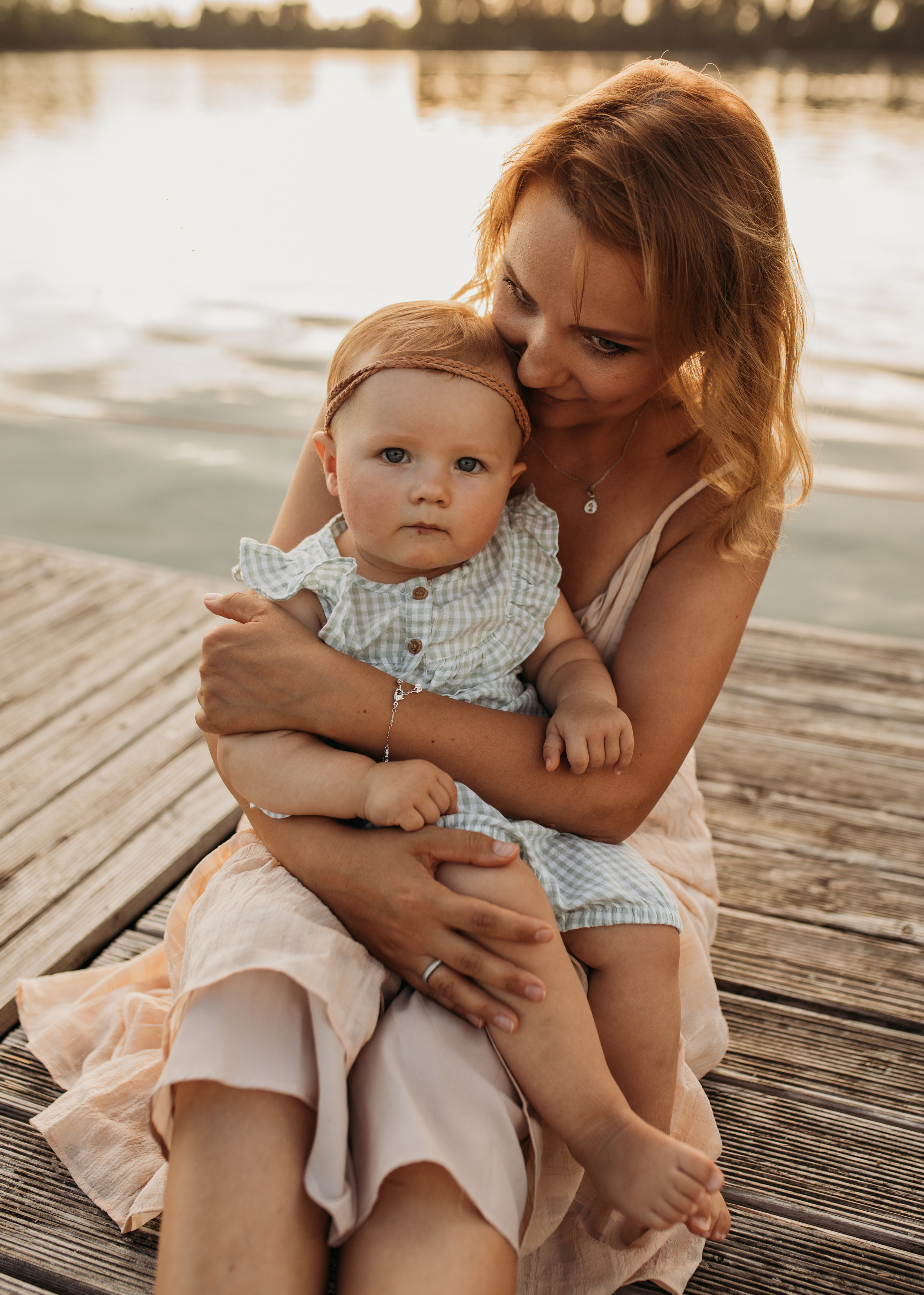 Mutter hält liebevoll ihre Tochter auf dem Schoss auf dem Strand beim Familienshooting in Mannheim.