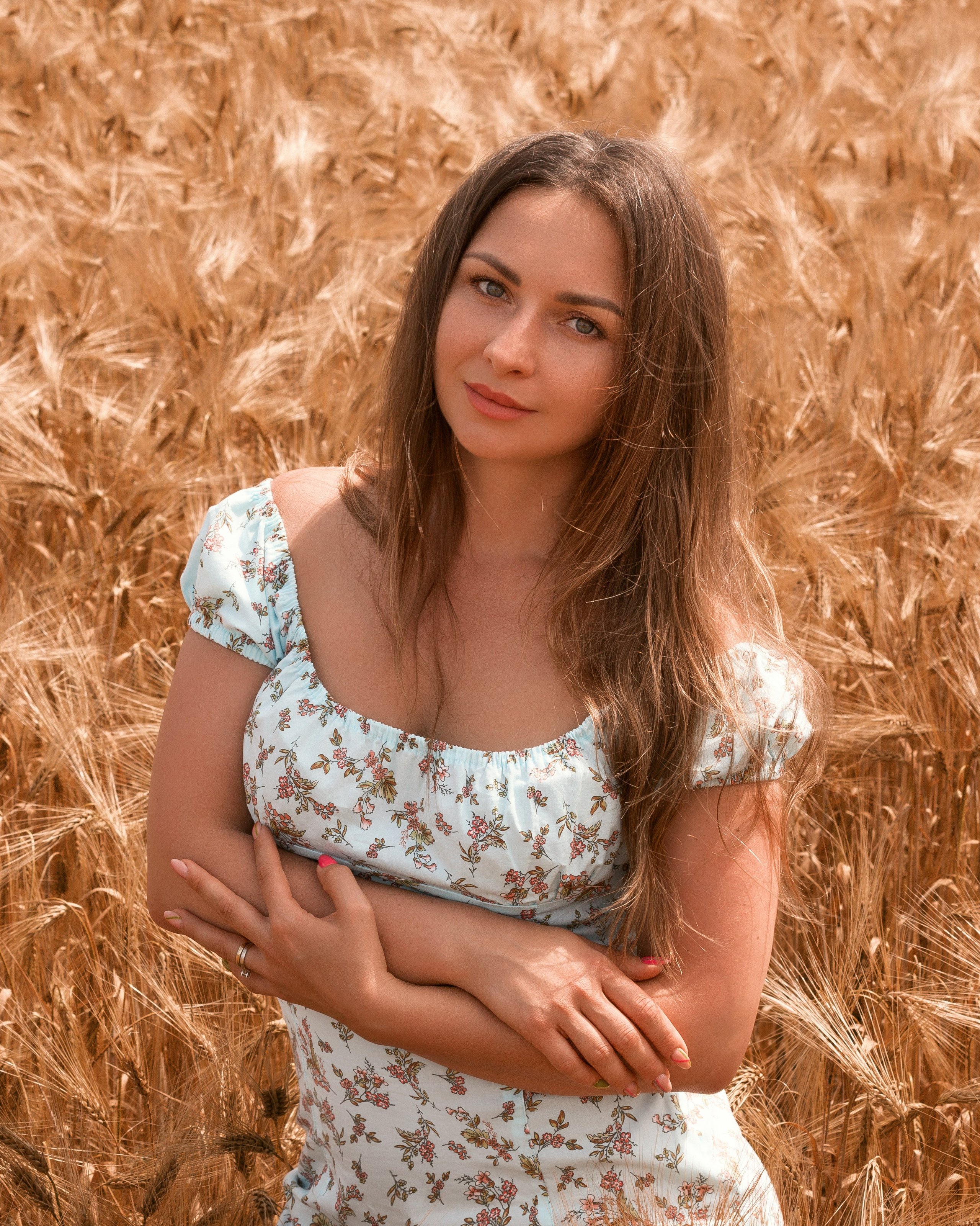 Sonnendurchflutetes Porträt einer Frau im blauen Kleid im Feld