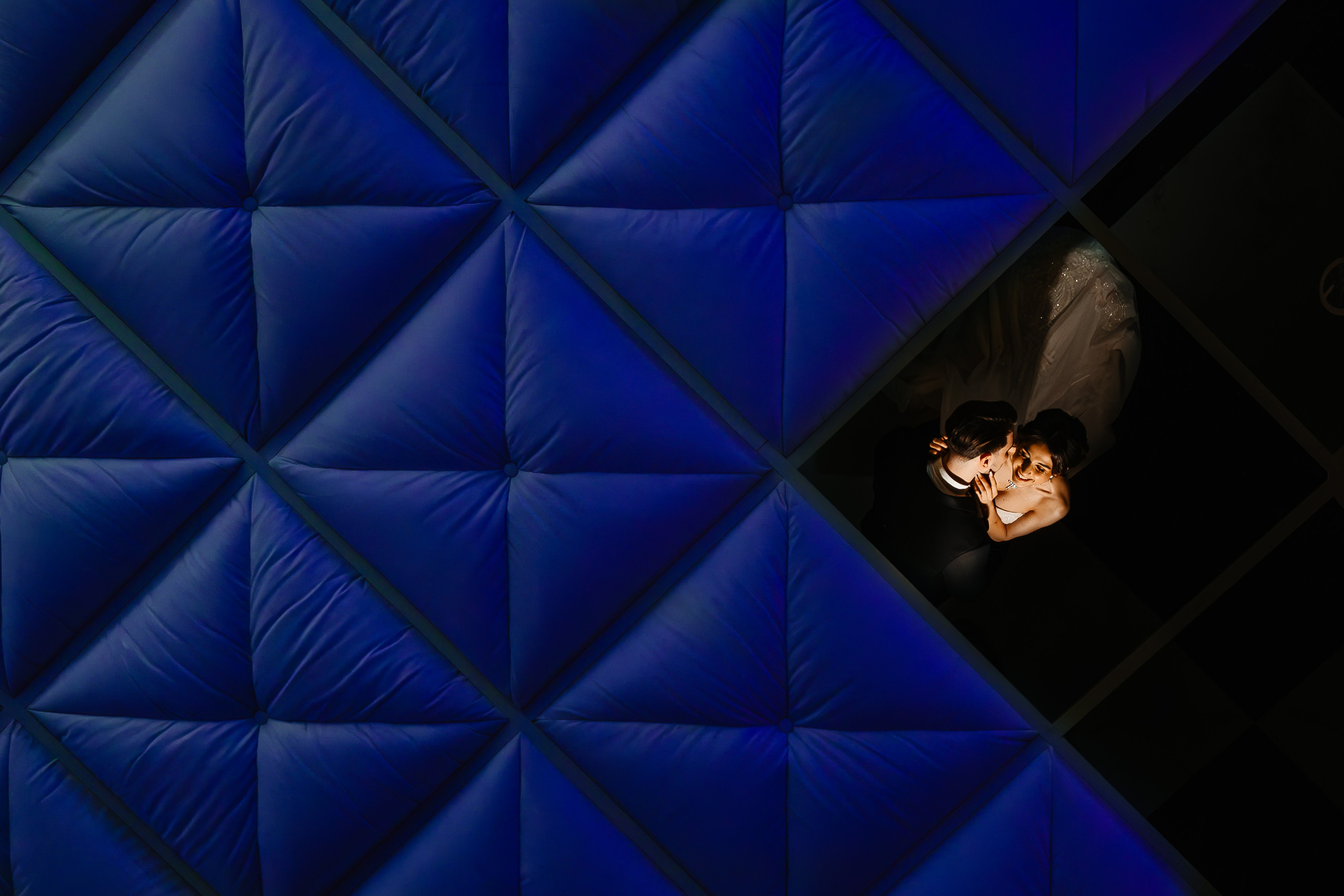 Portret creativ de mireasă reflectată într-un tavan geometric albastru