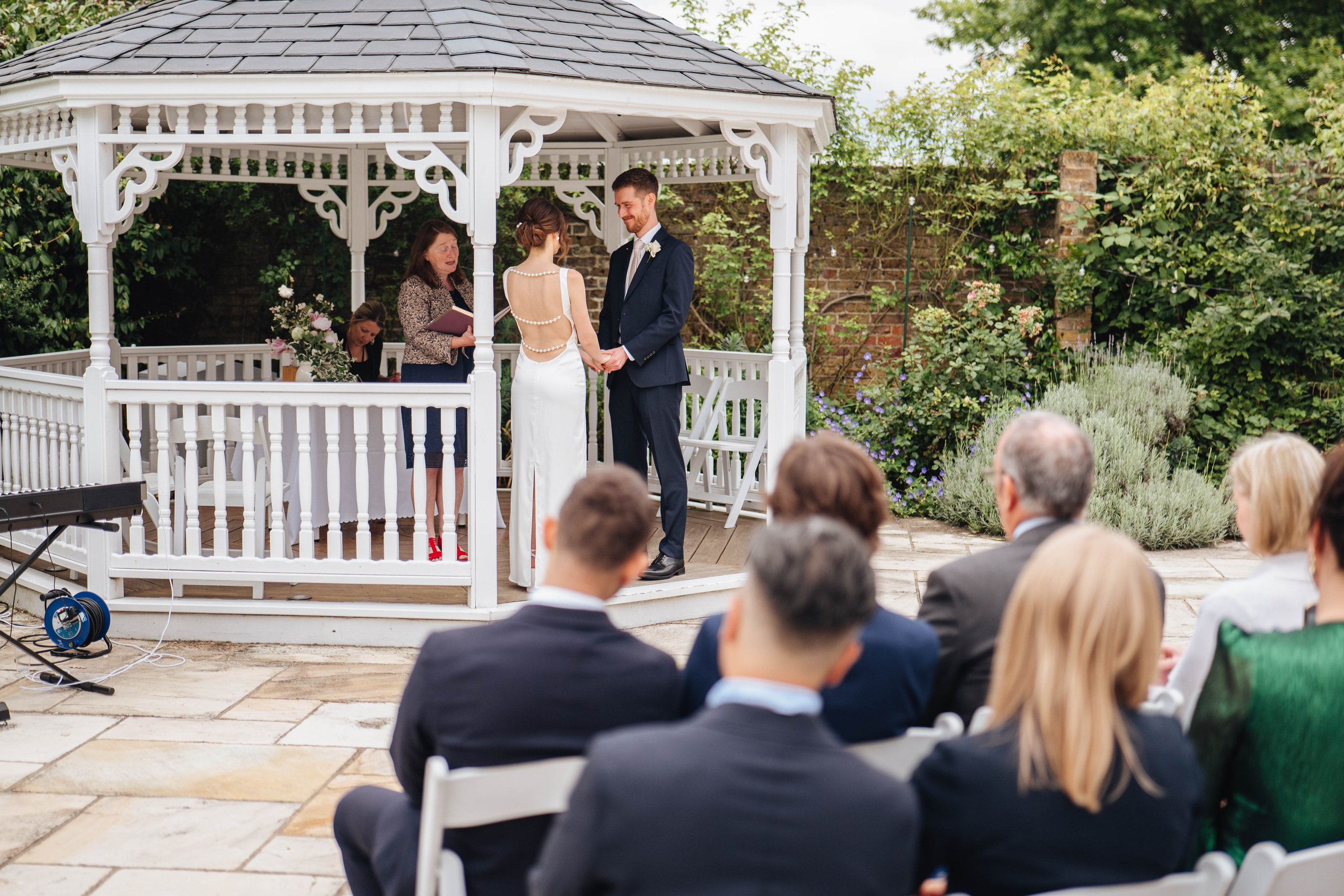 bride and groom at the ceremony, holding hands