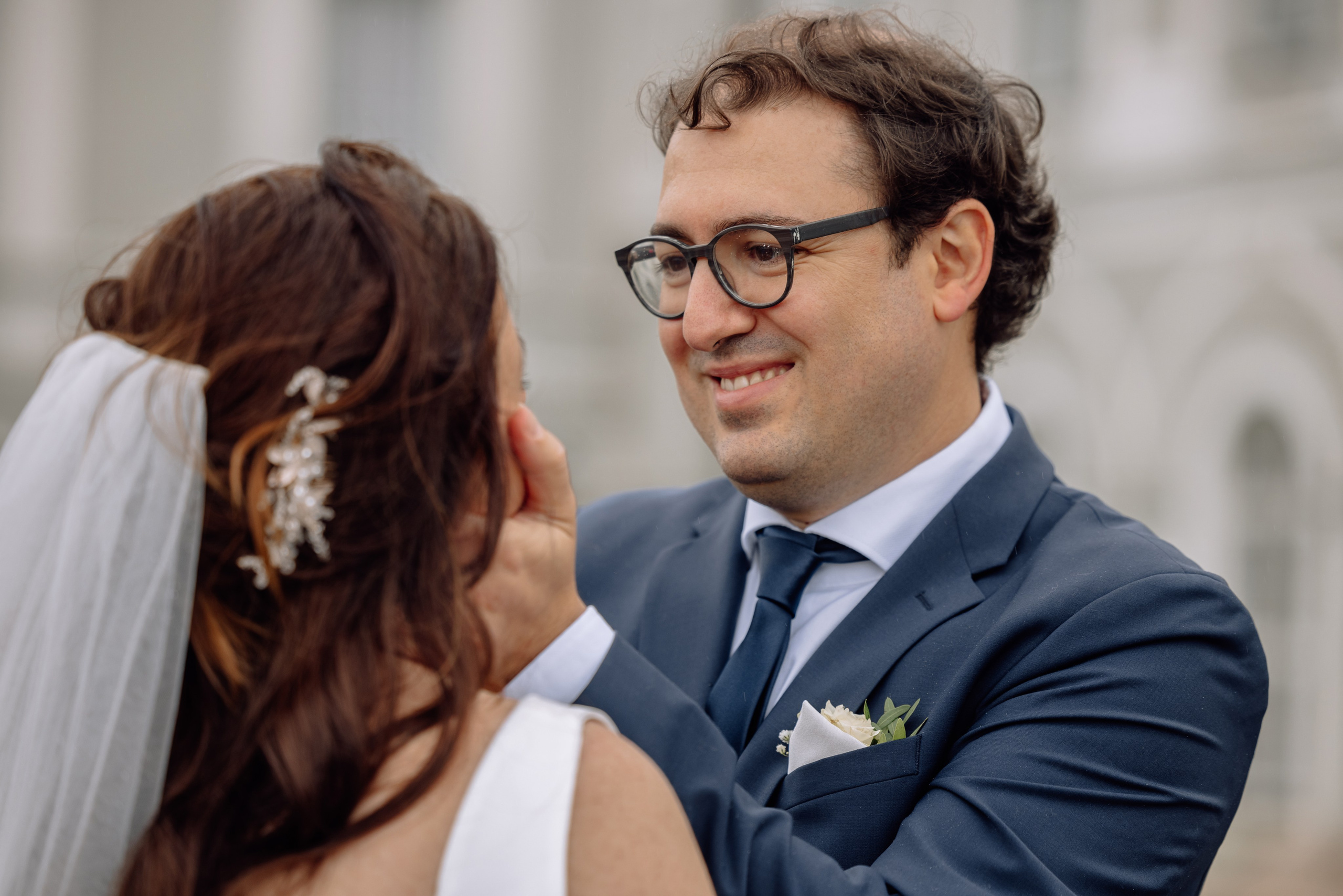 Bräutigam hält das Gesicht der Braut vor dem Schloss Nymphenburg