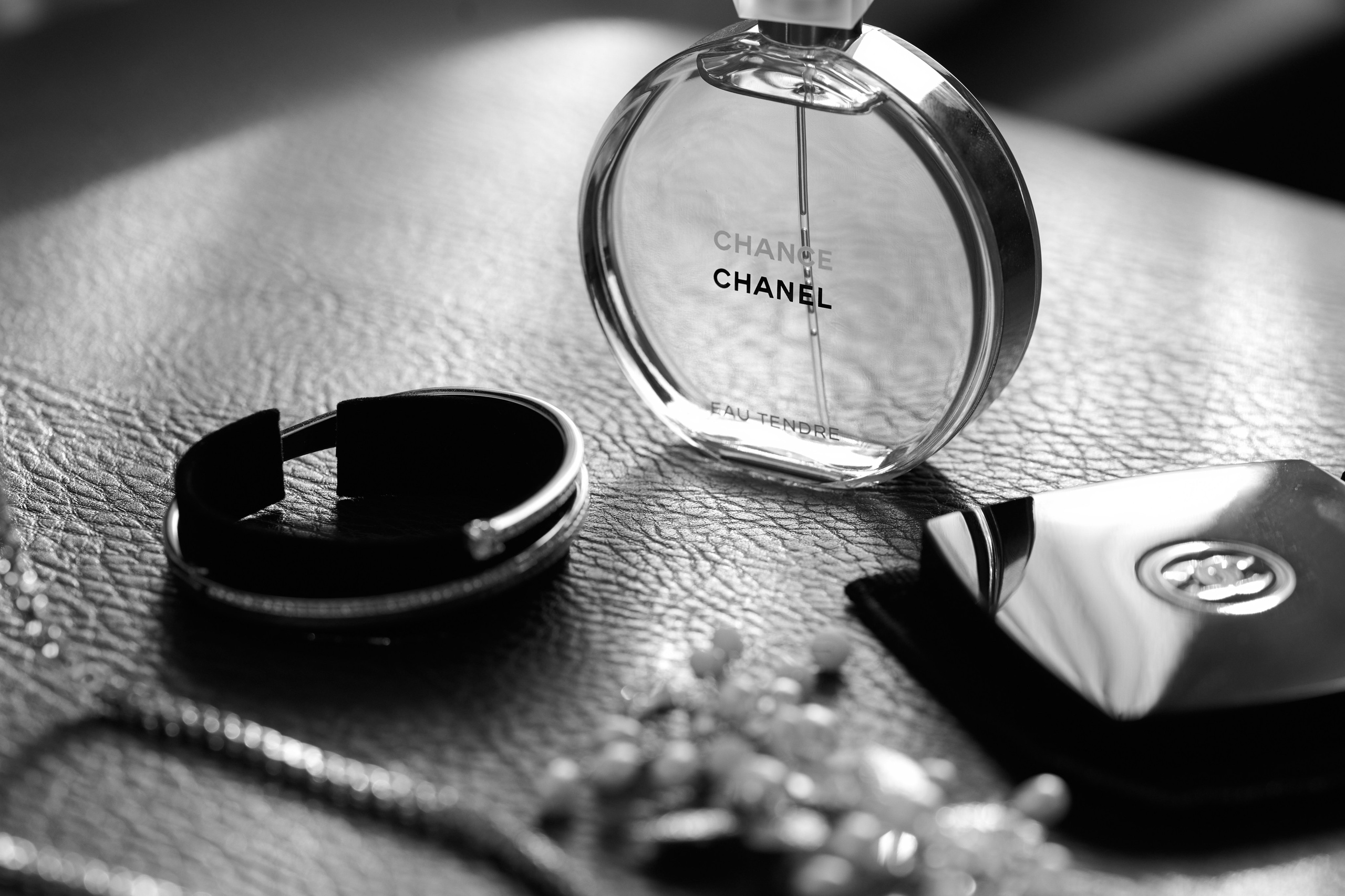 Elegante Detailaufnahme bei der Hochzeit in Karlsruhe – CHANEL-Parfum und Brautaccessoires auf Leder im natürlichen Licht.
