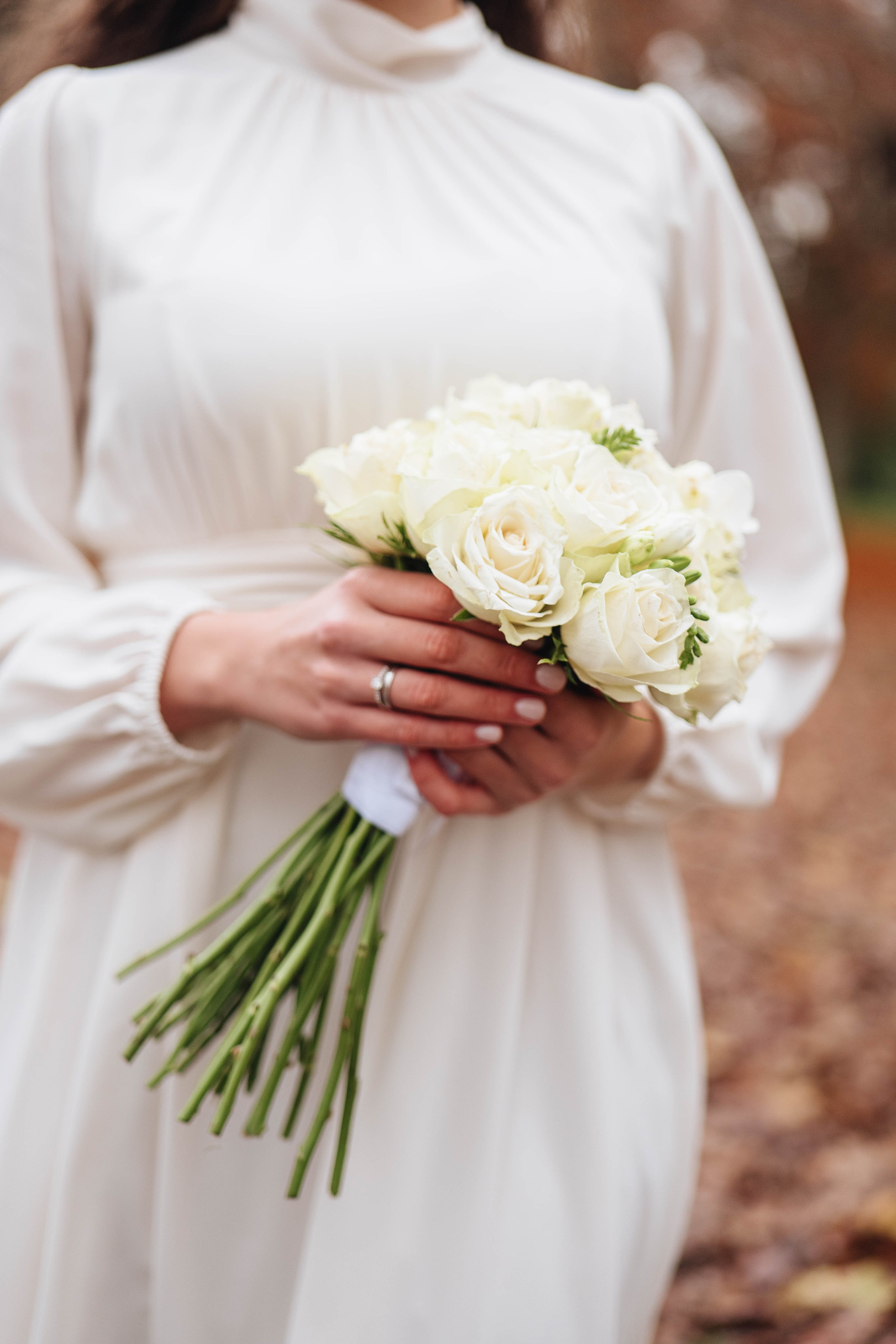 The bride walking along in an autumn park with a bouquet of flowers.