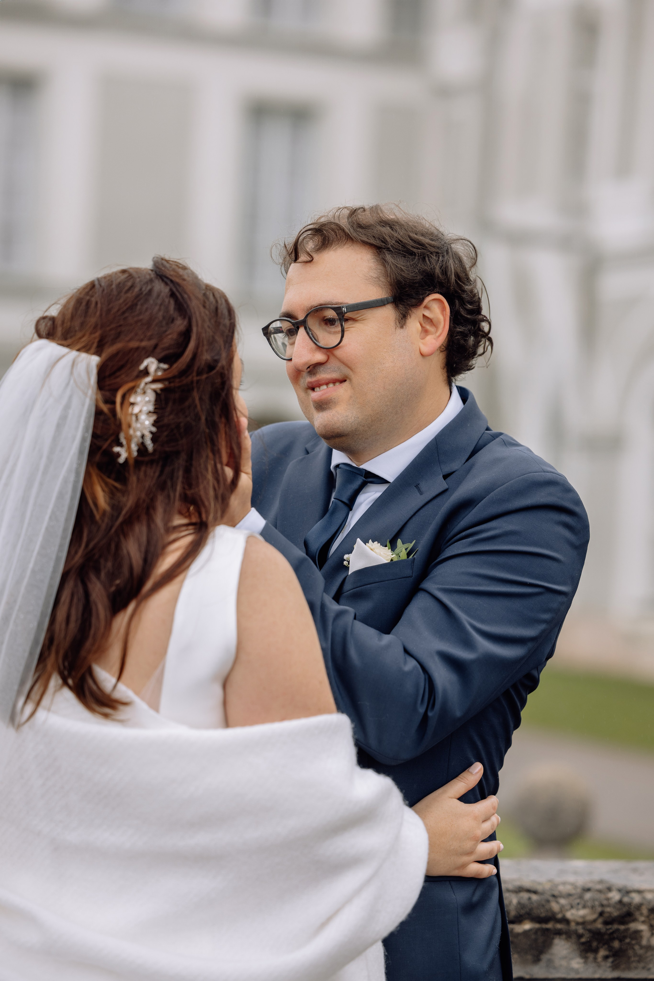 Bräutigam berührt das Gesicht der Braut s vor dem Schloss Nymphenburg