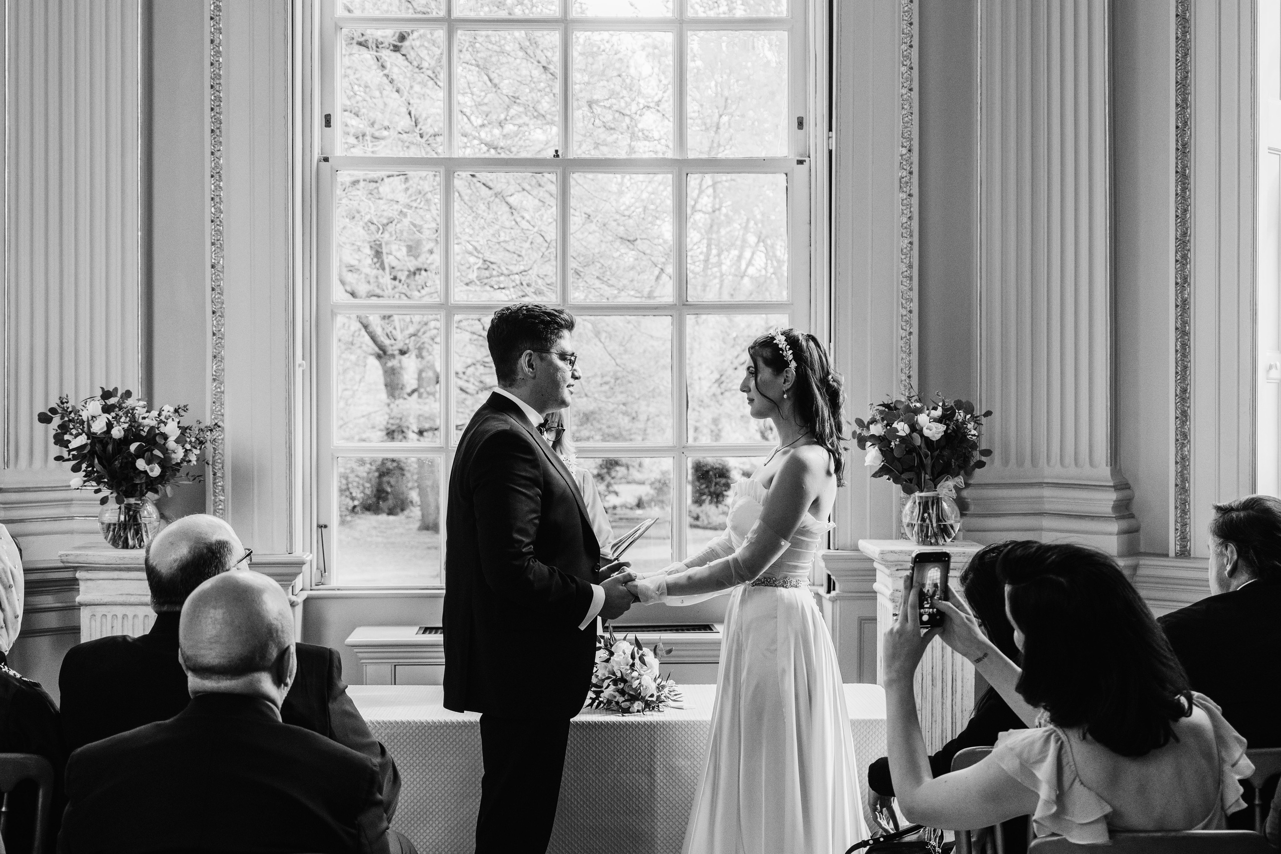 black and white photo of the wedding ceremony, bride and groom holding hands