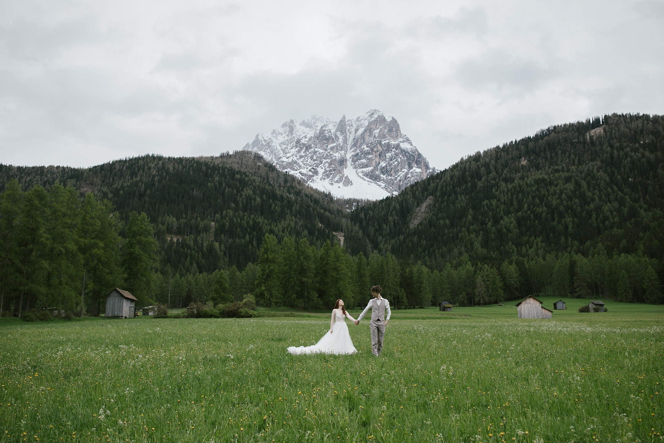 Alpenhochzeit in Südtirol – Brautpaar Hand in Hand vor Dolomitenkulisse