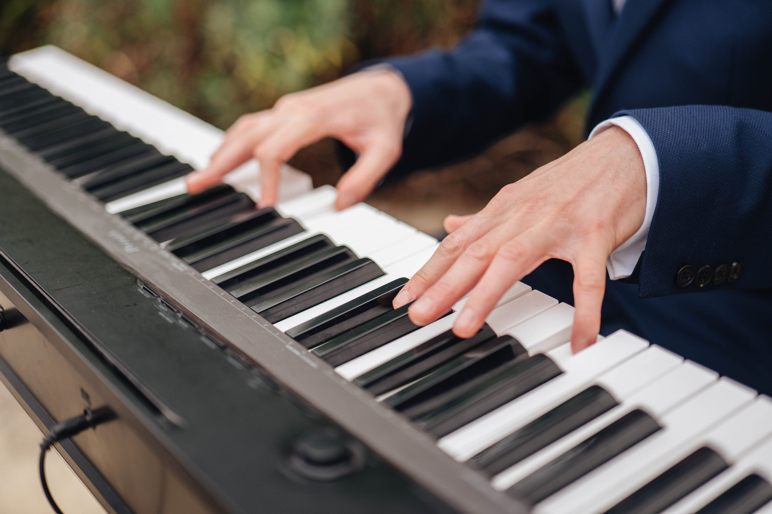 hands closeup of a friend of a family playing piano at the wedding ceremony