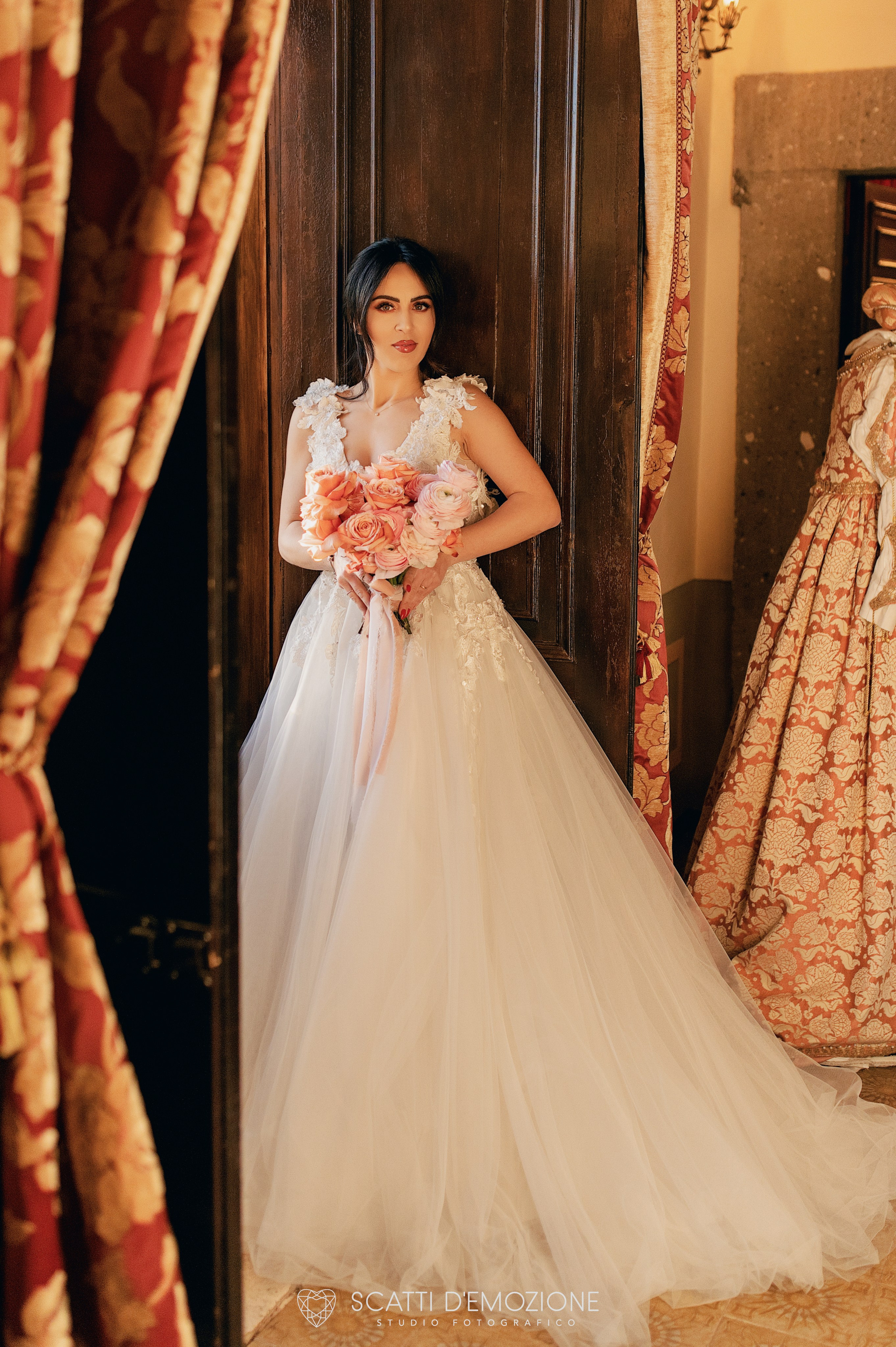 sposa in antica villa da matrimonio con vestito rosa e bouquet in mano