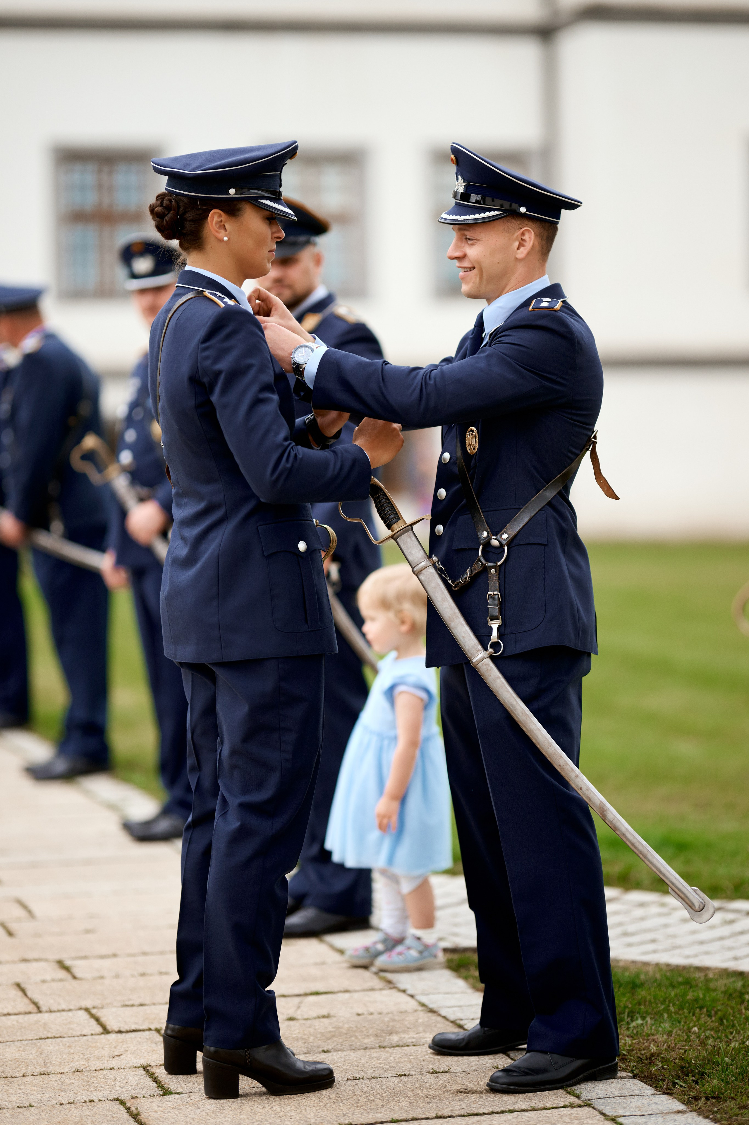 Persönlicher Moment während der Vorbereitung zur Ehrenparade – ein Offizier der Luftwaffe hilft seiner Kollegin in Meßkirch mit liebevoller Geste. Hochzeit in Meßkirch