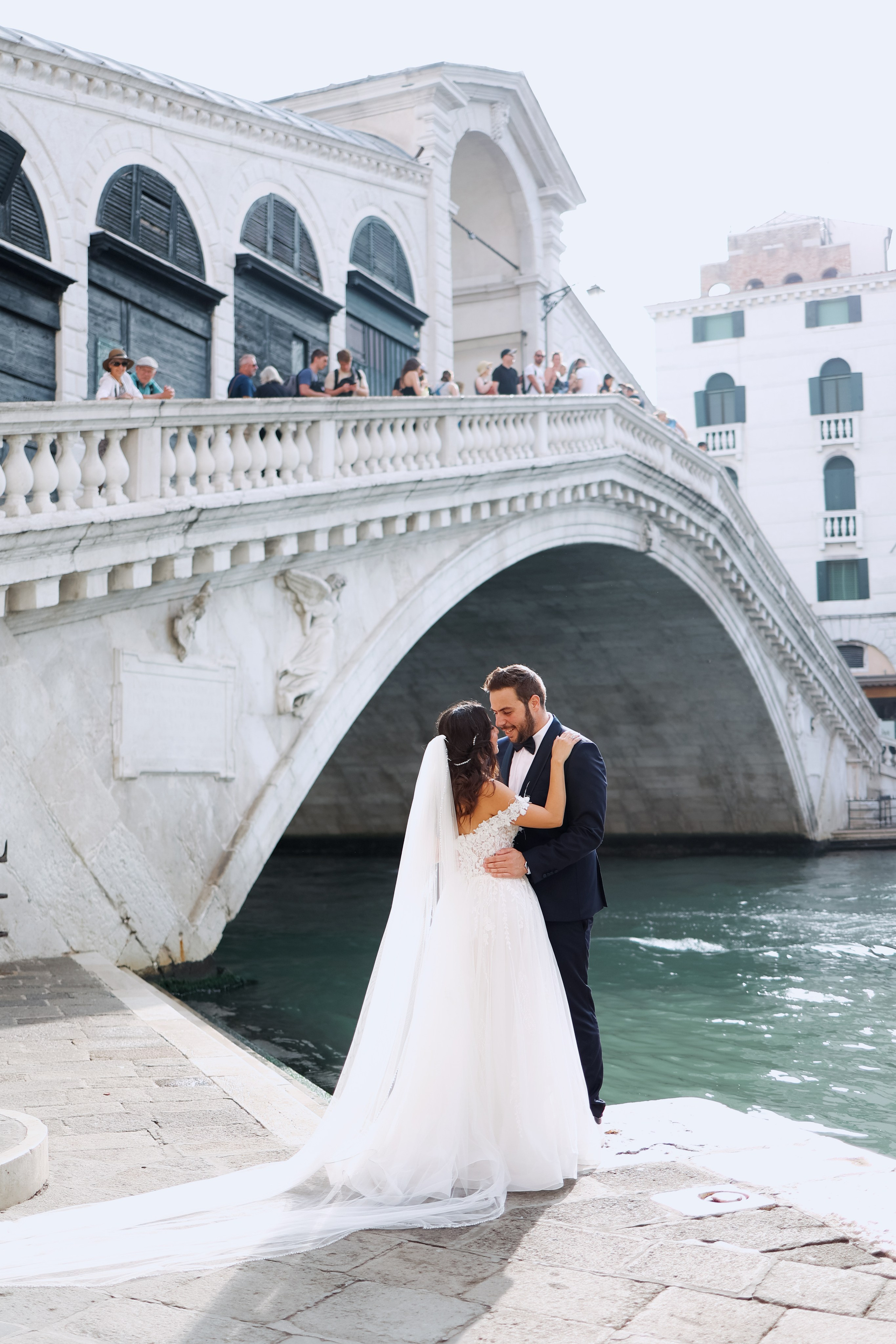 Couple sating next the Rialto bridge of Venice