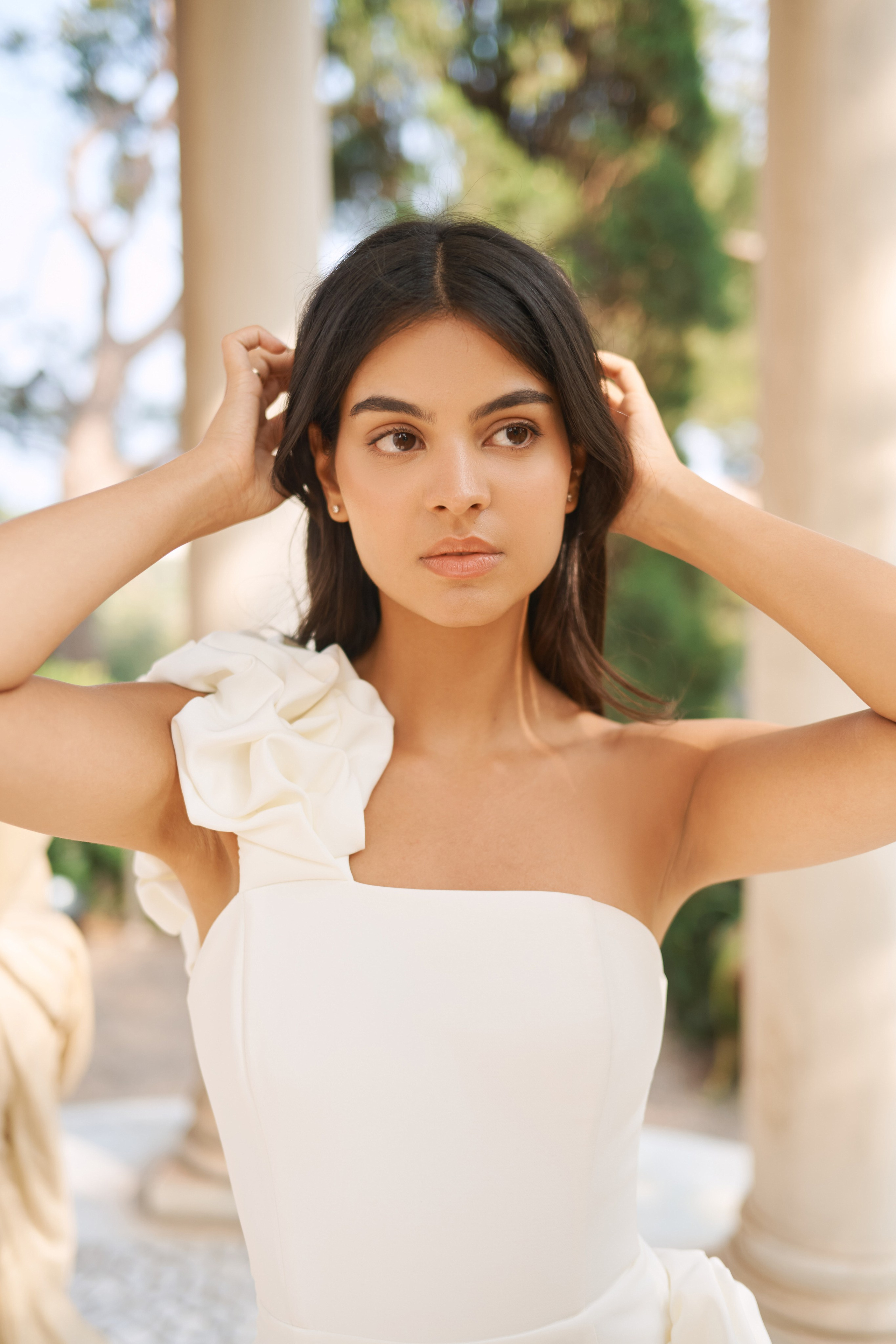 Elegant woman in flowing dress posing in lush garden at Rothschild Villa