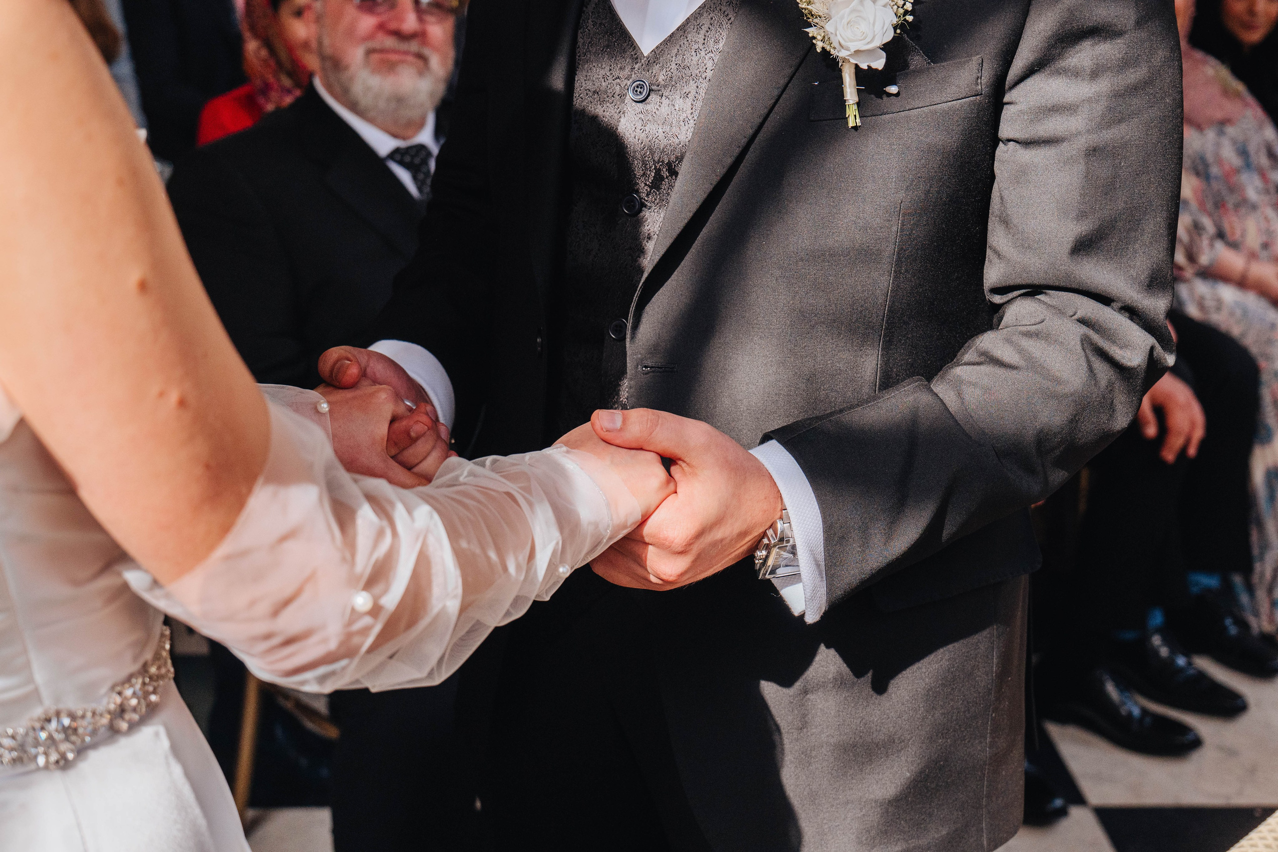 photo of the wedding ceremony, close up of bride and groom holding hands