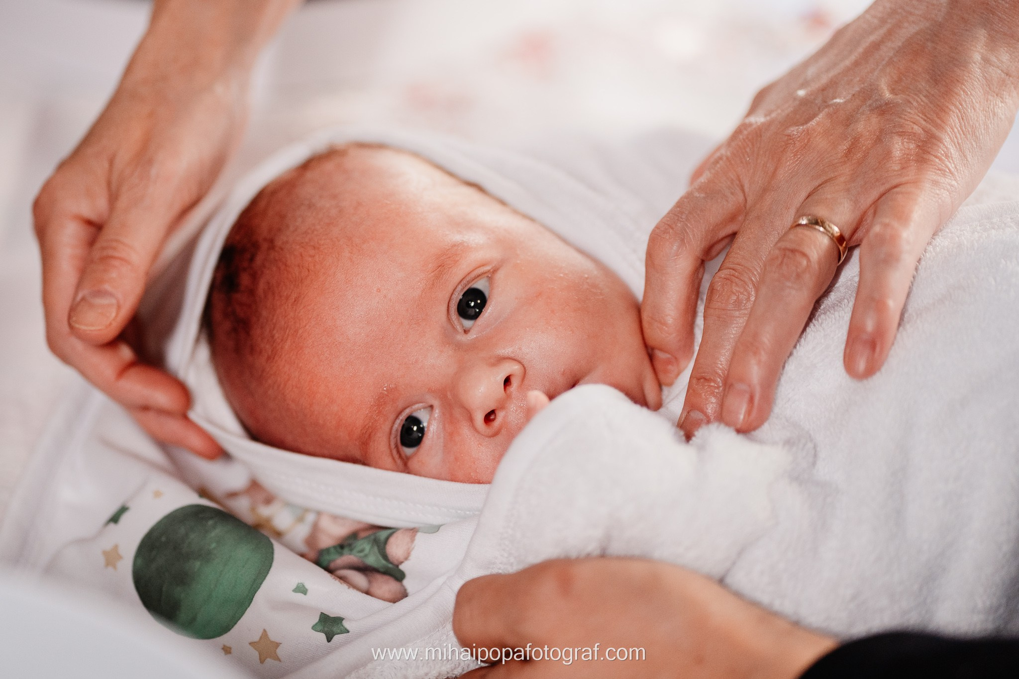 Instantaneu plin de tandrețe dintre părinți și bebeluș în ziua botezului, realizat în ilfov. Fotografie profesională de botez, capturând emoțiile autentice ale familiei într-un decor luminos și cald