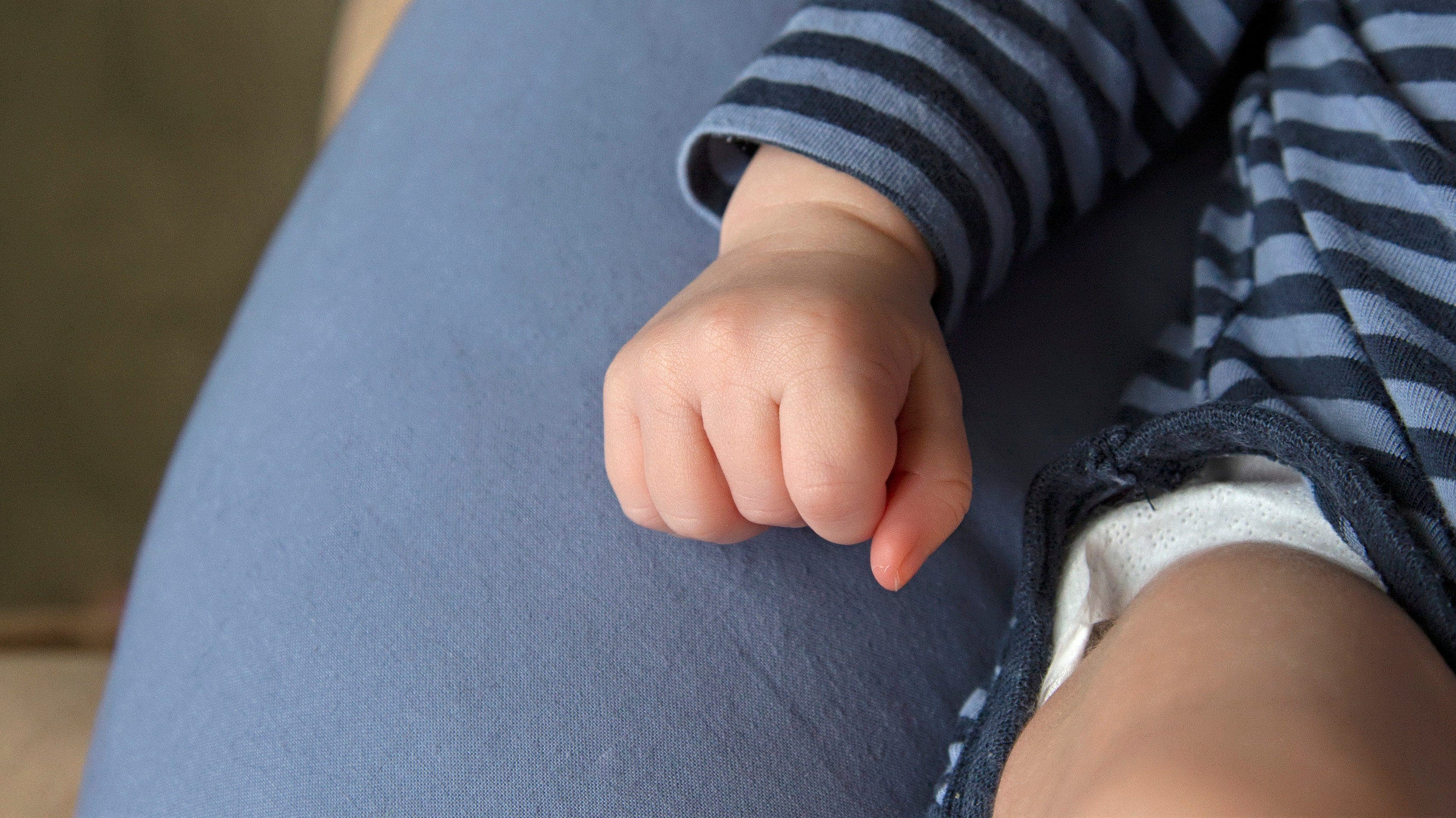 Close-up of newborn baby's tiny hands, delicately curled, showcasing innocence and tenderness