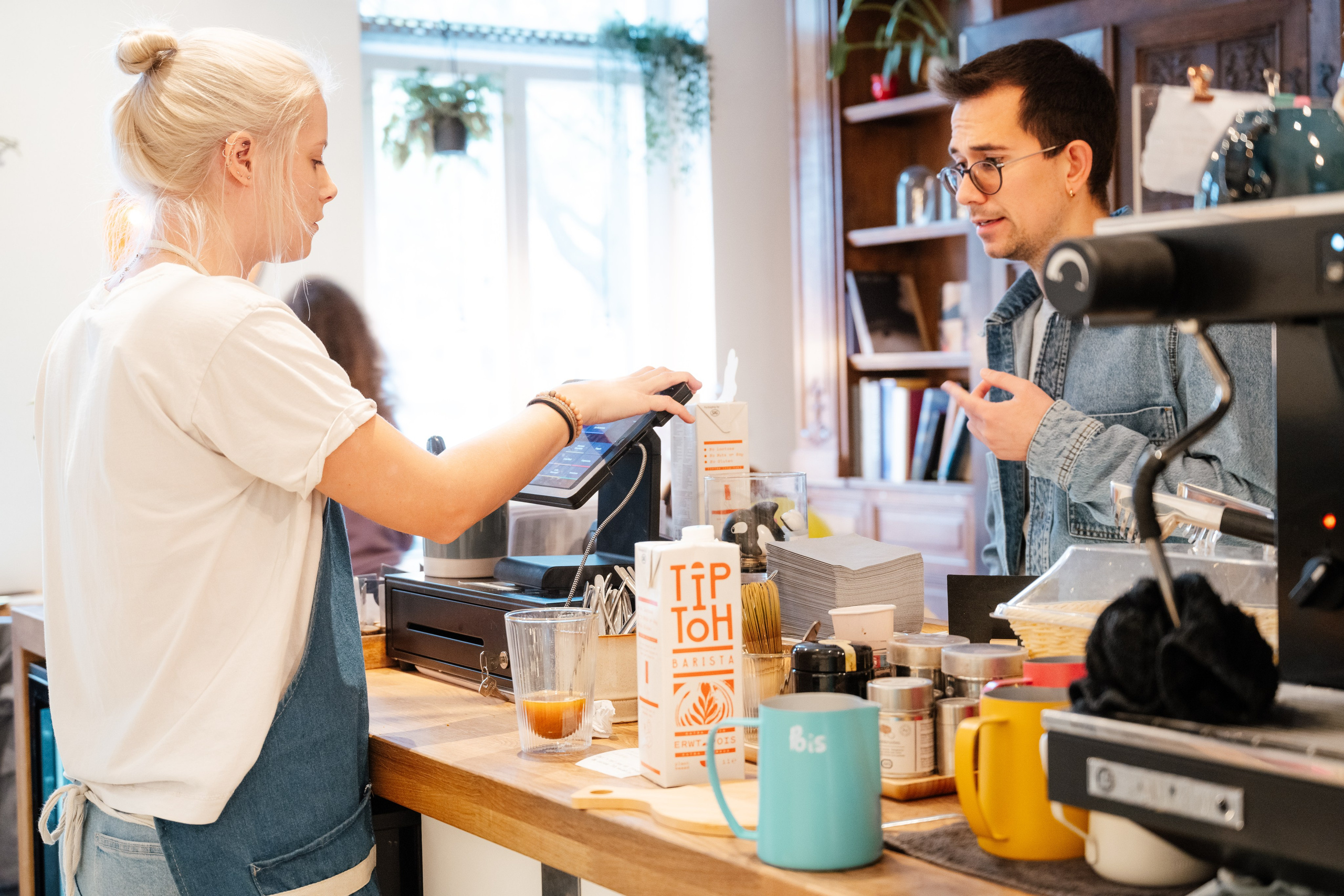 Scenă cu barista în acțiune, atmosferă autentică de cafenea urbană, fotografie comercială pentru branding horeca
