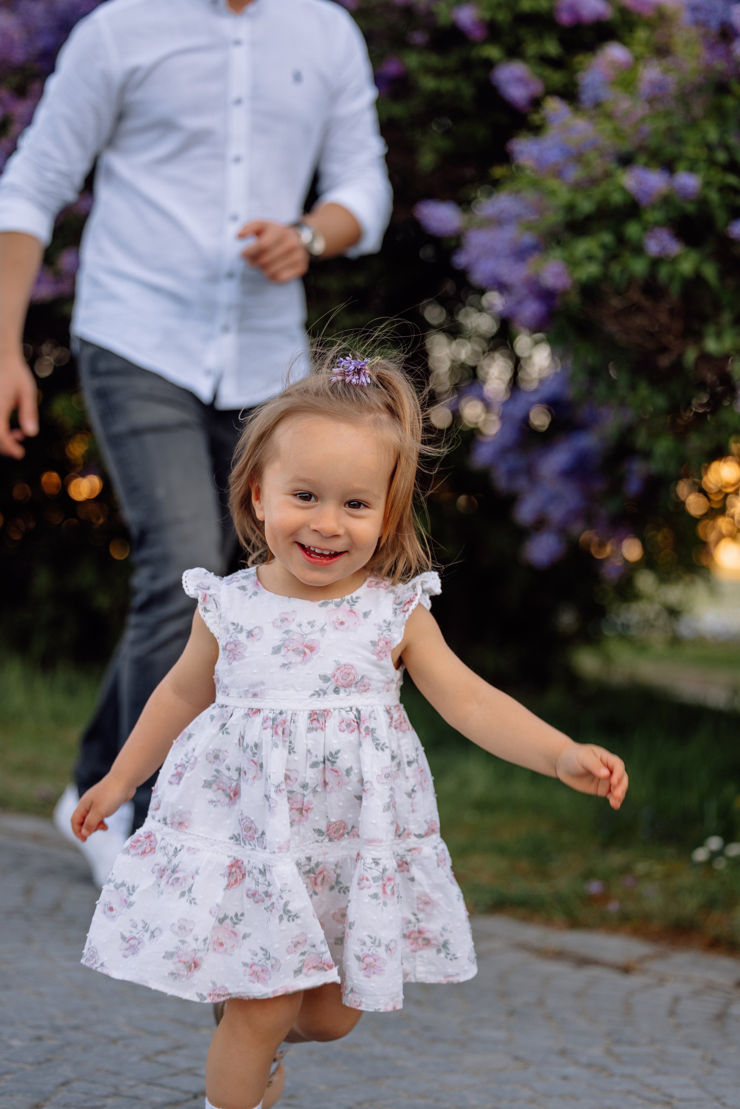 Kleine Tochter rennt lachend über die Wiese vor dem Schloss Nymphenburg