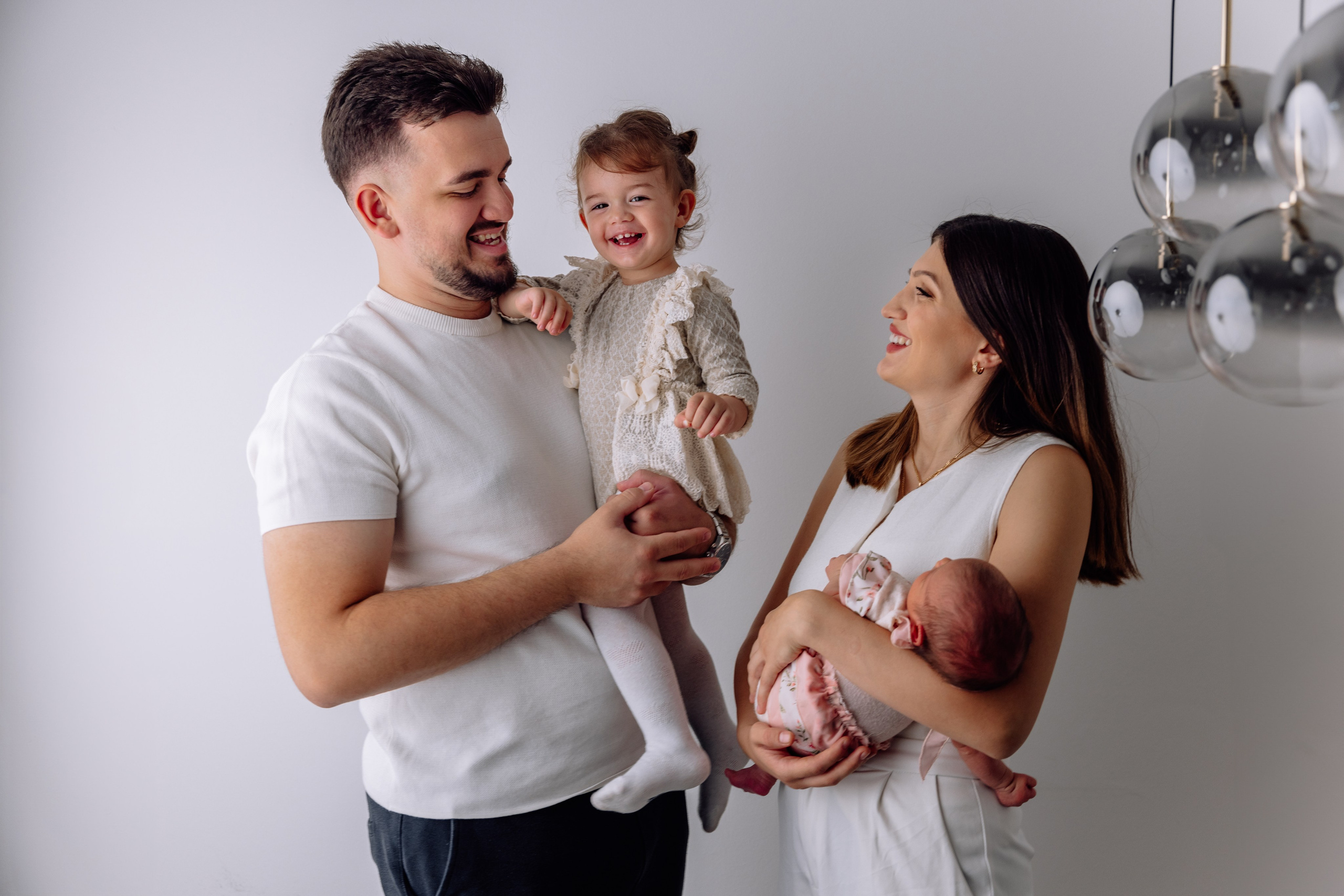 Mama und Papa lachen gemeinsam mit ihrem Kleinen – Familienfotografie zuhause.