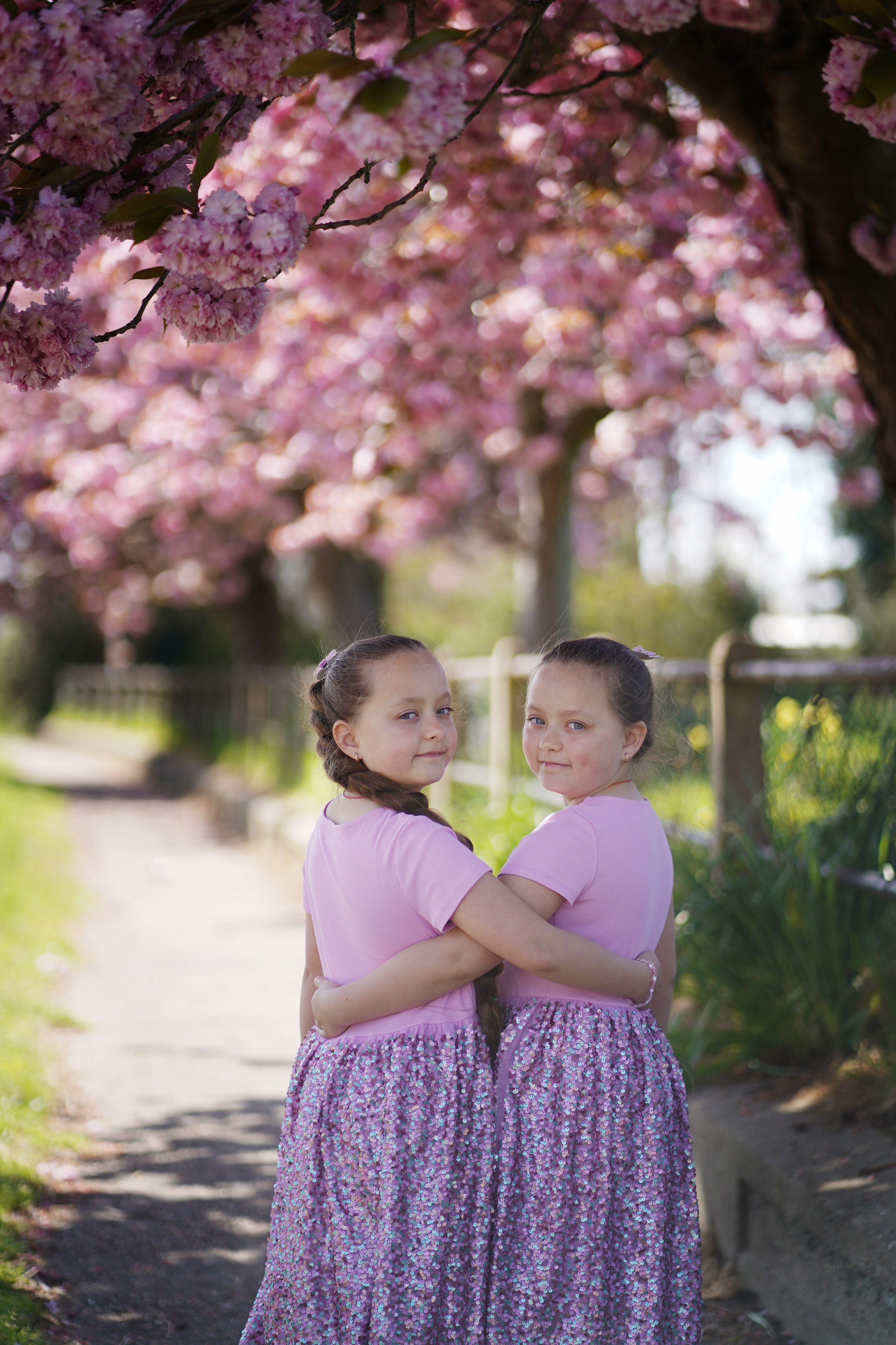 Little sisters in pink blossom. Jelena Upleja children and family photographer in Bognor Regis
