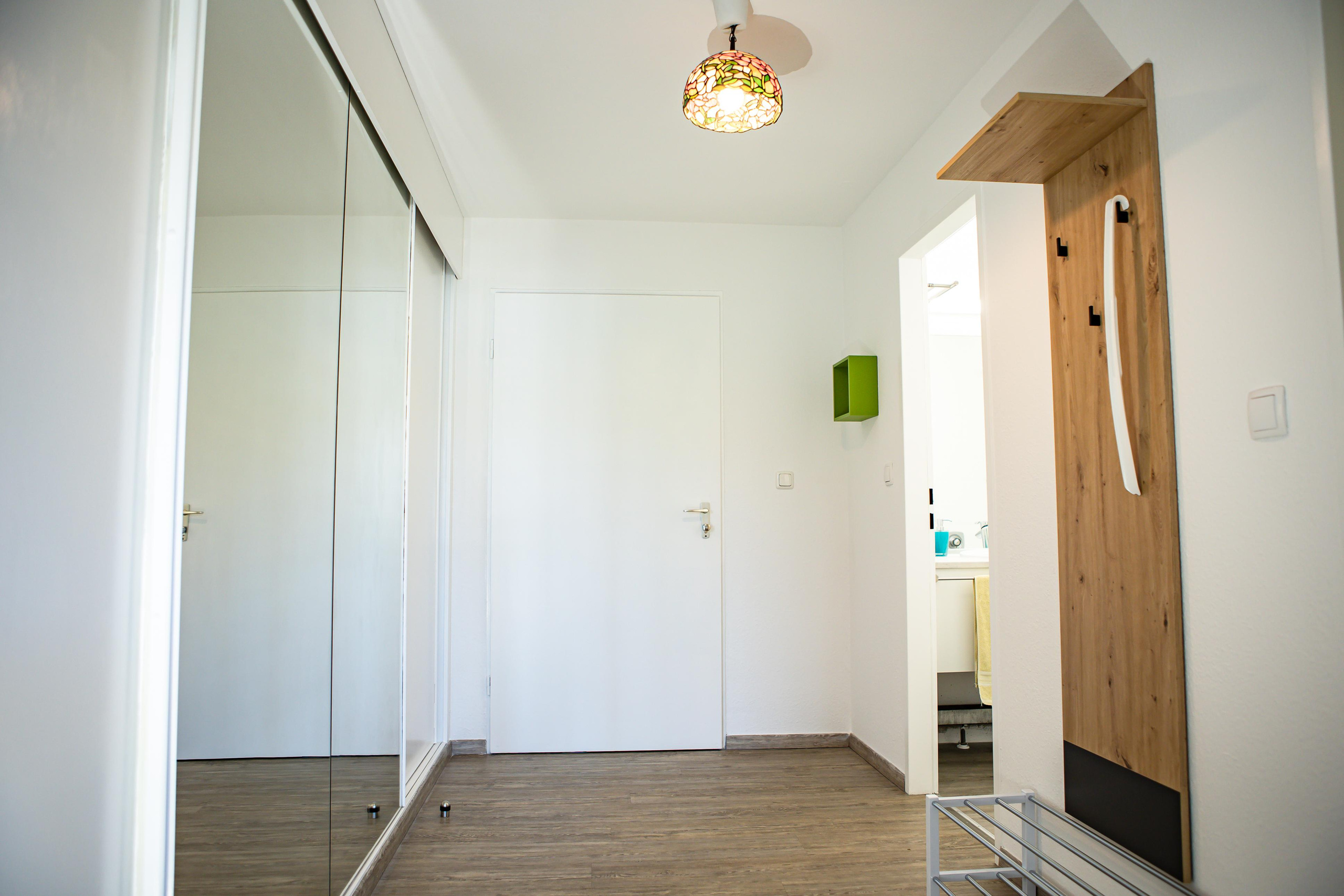 Fotografie des Flurs mit Spiegel und praktischen Schränken, aufgenommen von einem Immobilienfotografen