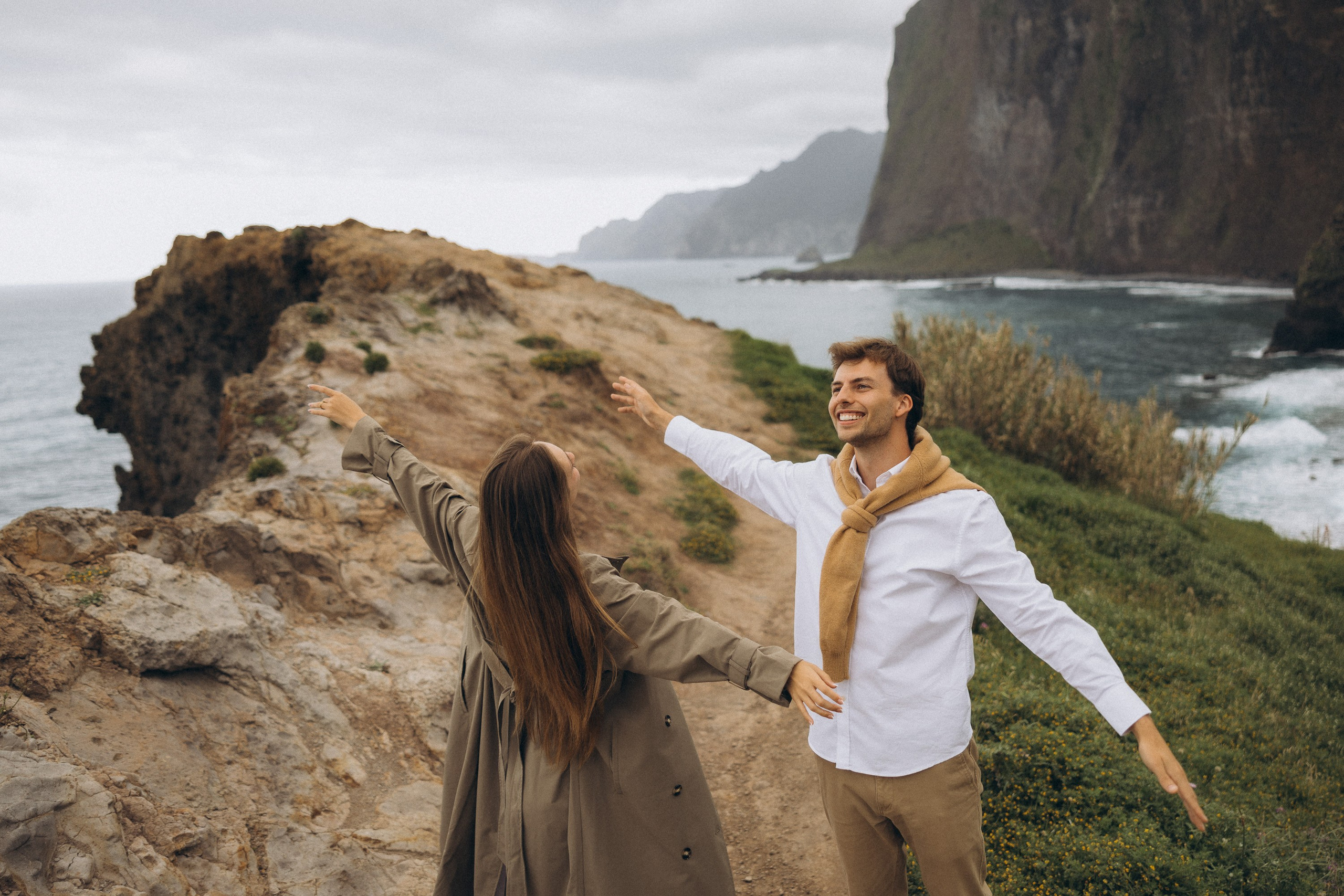 Romantic surprise proposal at sunset on a scenic cliffside in Madeira, Portugal, capturing the emotional moment of love and commitment.