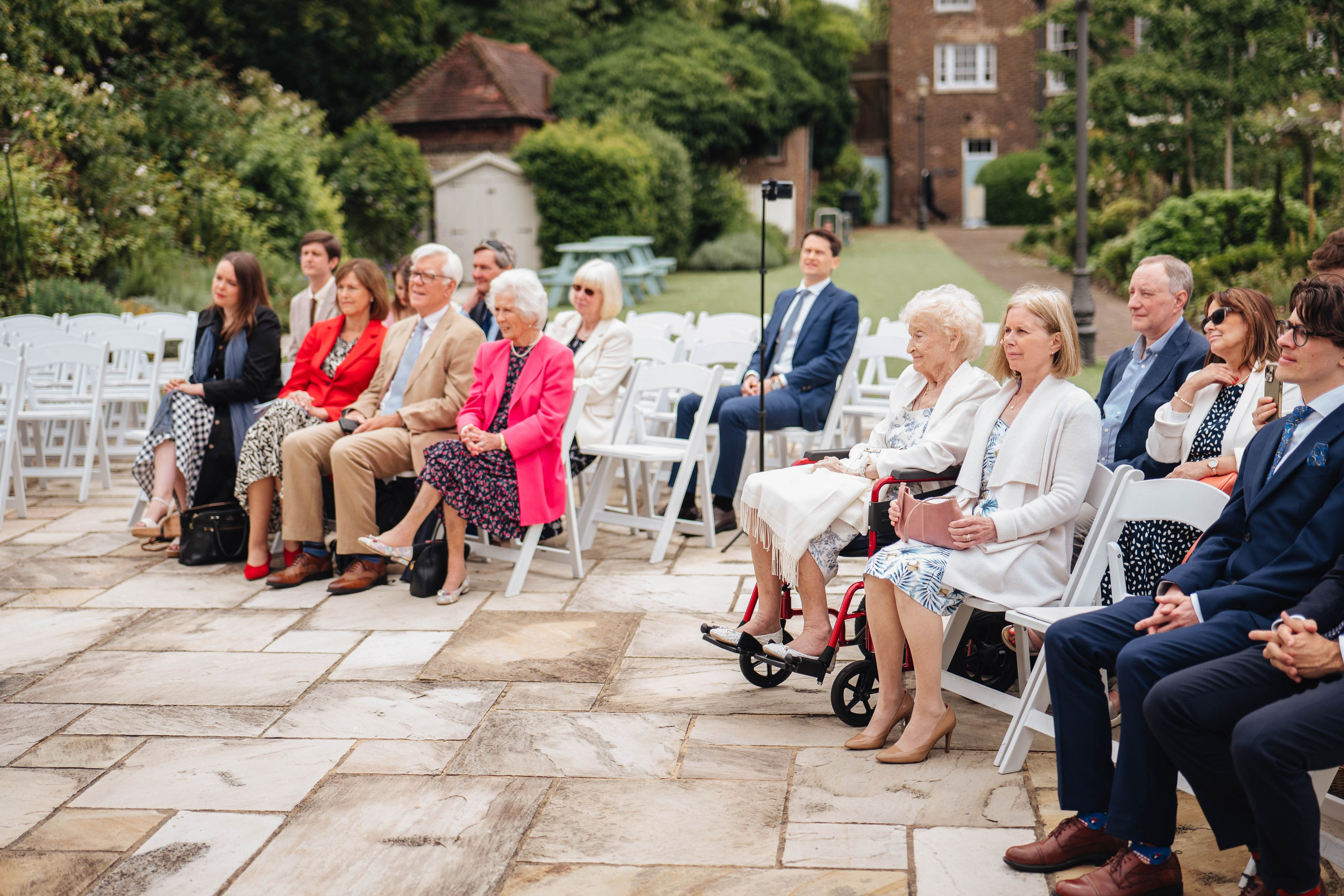 a group photo of family and friends sitting during the wedding ceremony