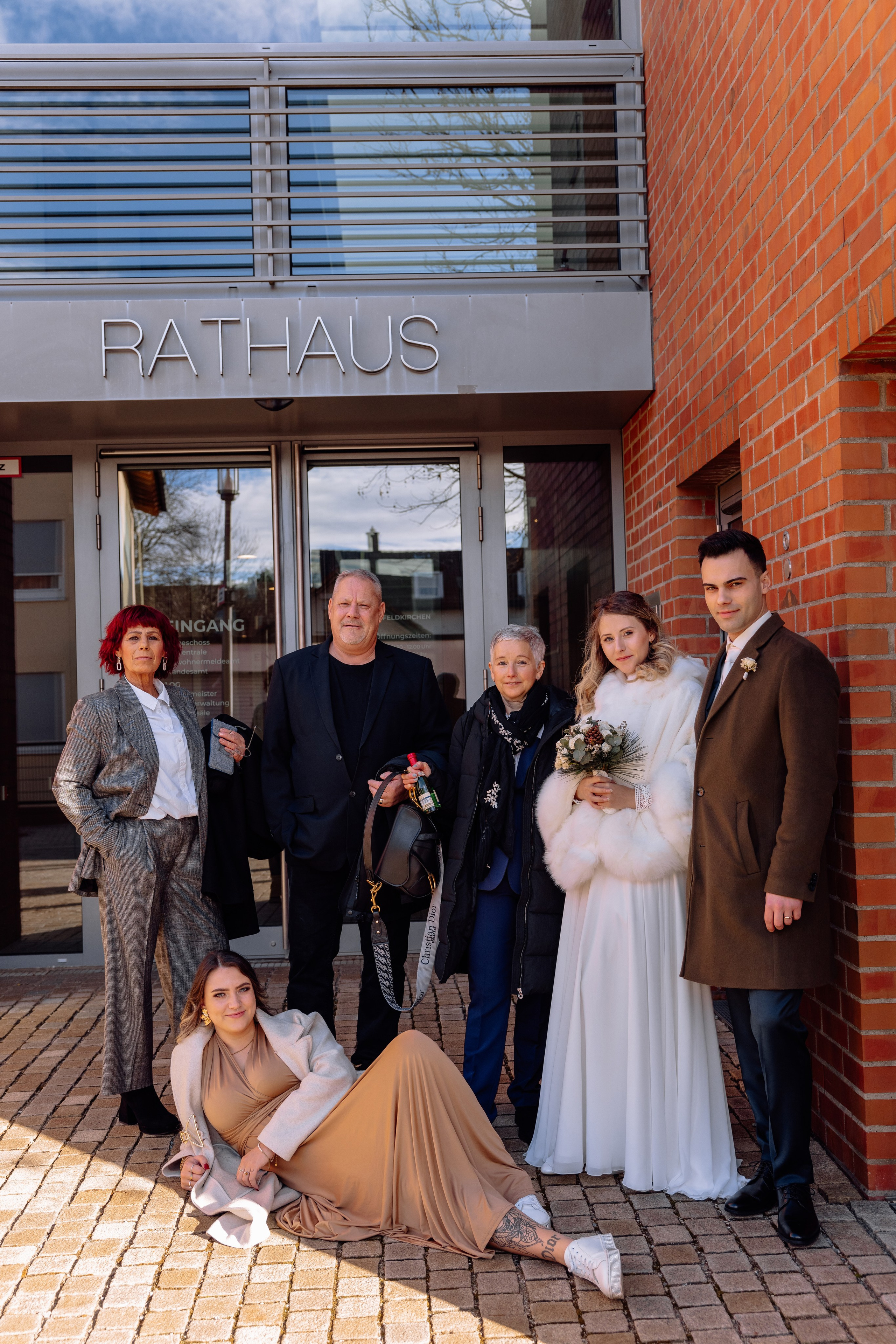 Paar mit den Gästen posieren vor dem Standesamt Feldkirchen
