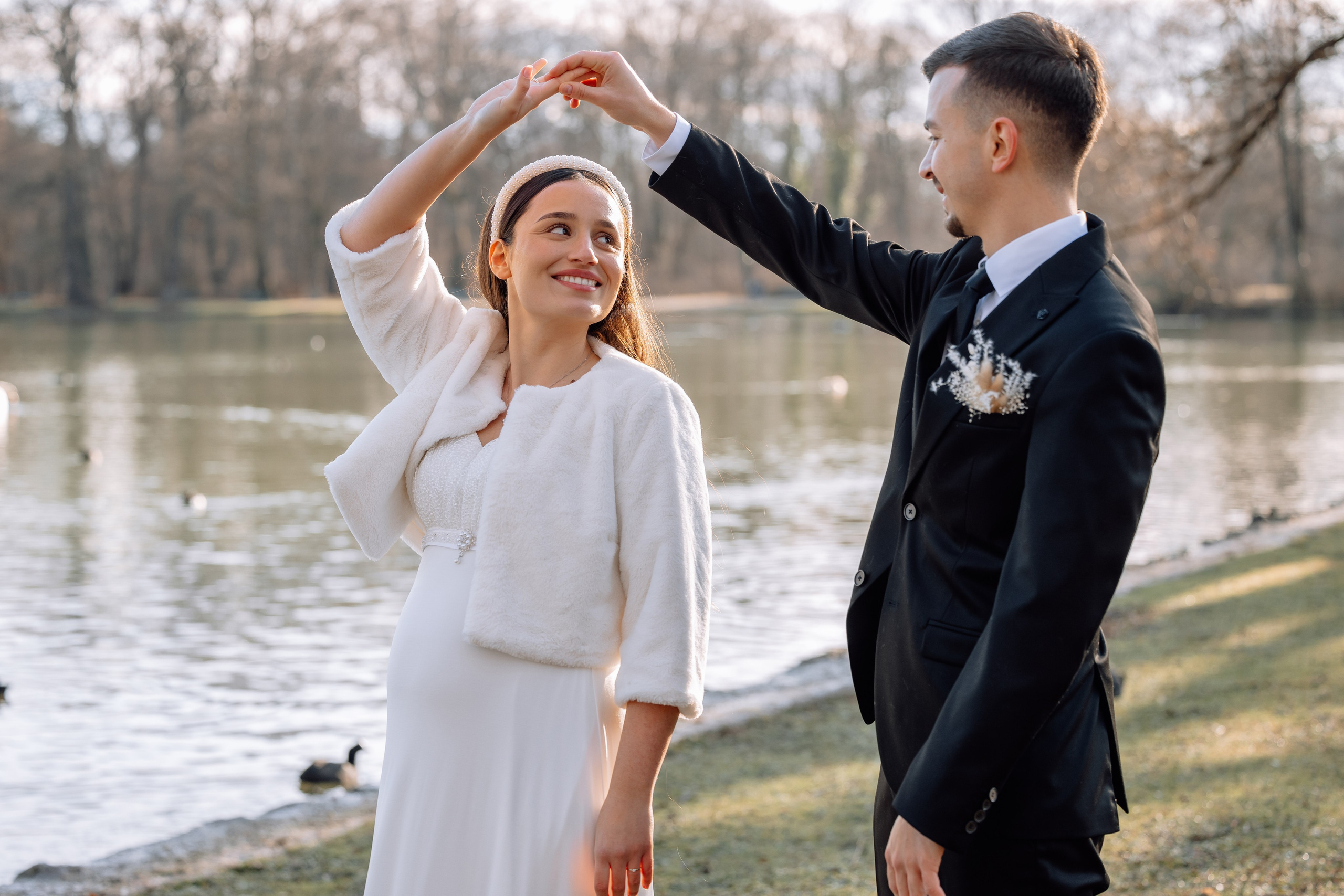 Braut spaziert neben Standesamt Schwabing im Englischen Garten mit Enten