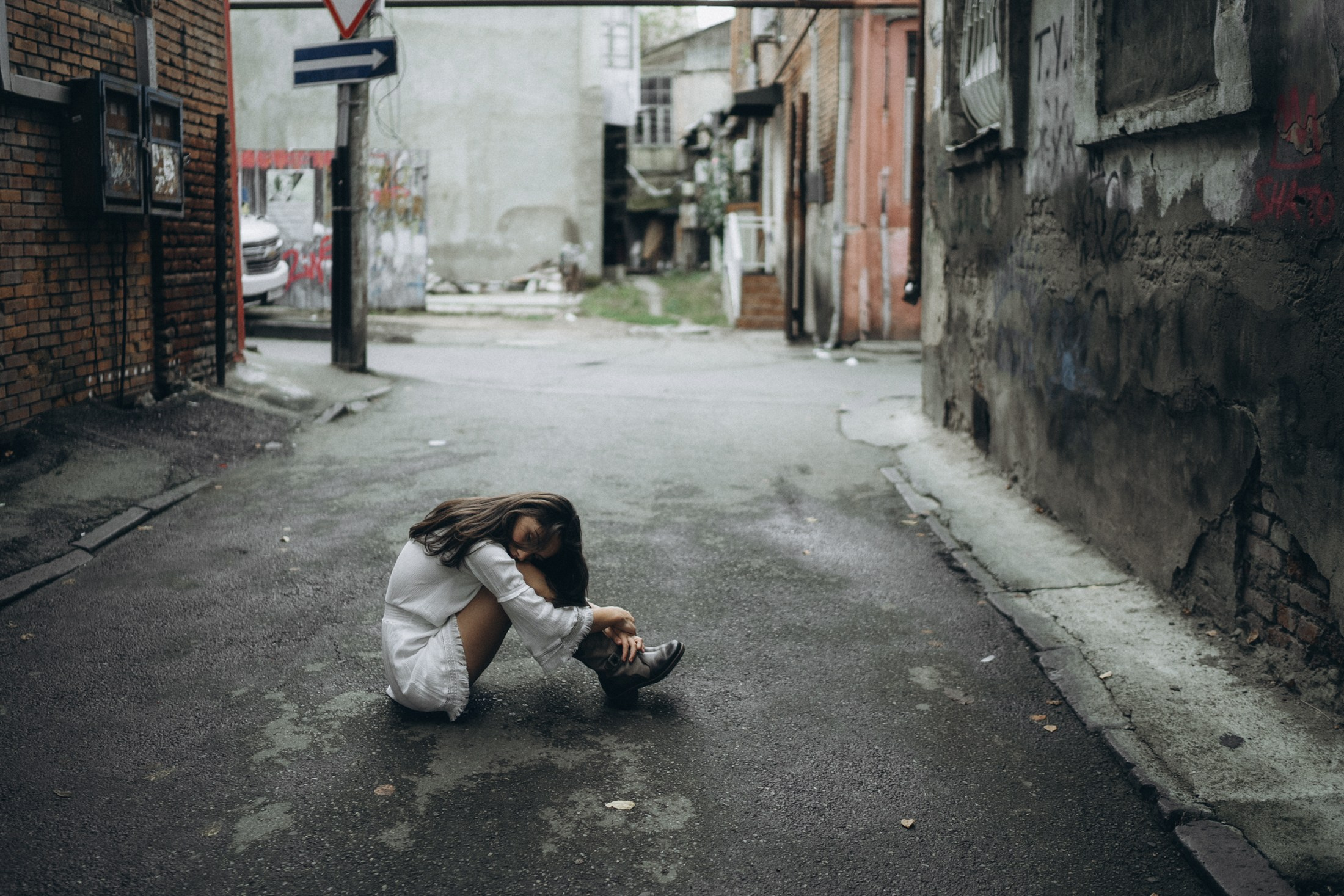 Frau in weißem Kleid allein in einer leeren Gasse – künstlerische Portraitaufnahme Dresden