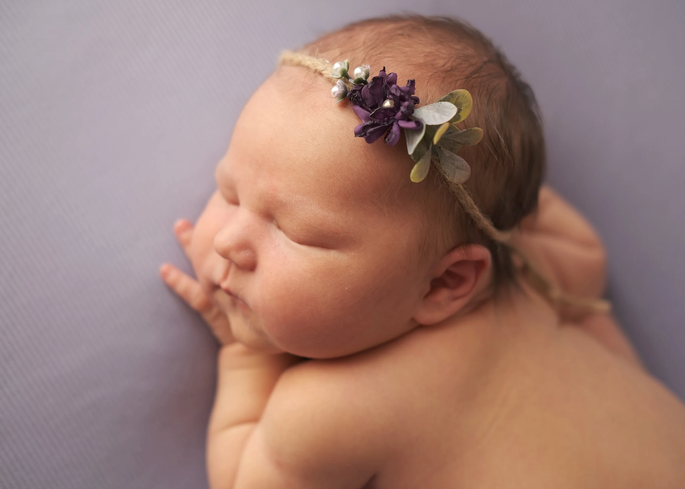 Newborn baby girl wearing delicate floral headband
