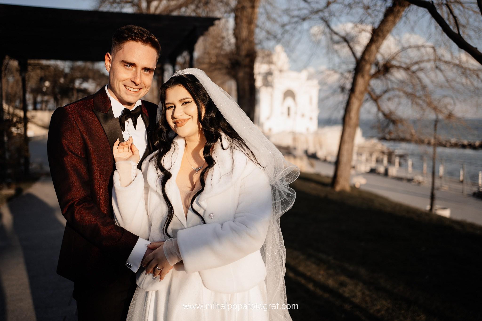 Moment emoționant între miri în ziua nunții, surprins într-un cadru natural și romantic, la Cazinoul Constanta. Fotografie de nuntă profesională, editată artistic pentru a evidenția emoția și eleganța evenimentului.