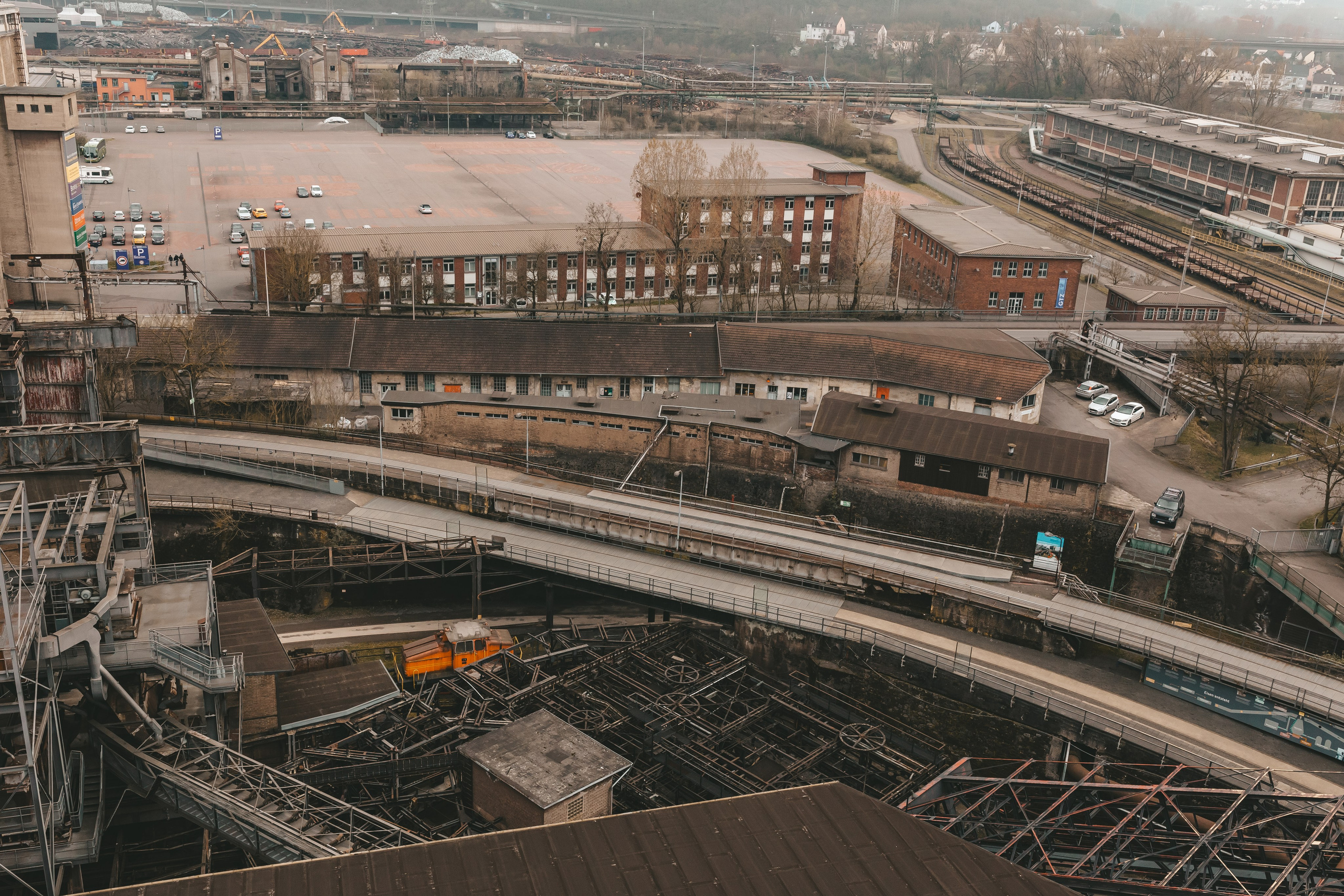  Ржавые трубы и опоры, и автомобильная парковка на территории бывшего металлургического завода Фёльклингер Хютте