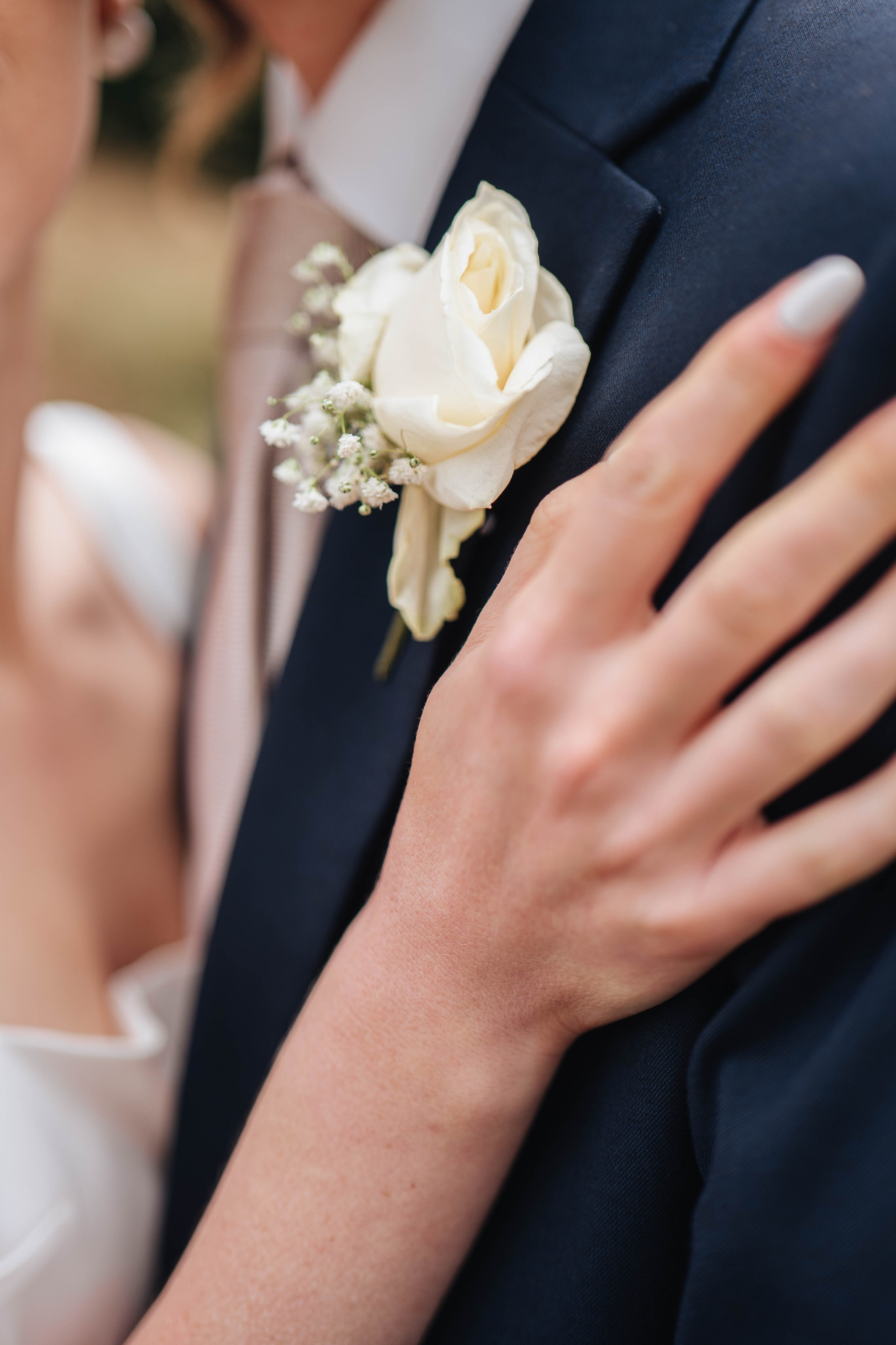 close up of the bride's hand on the groom's shoulder
